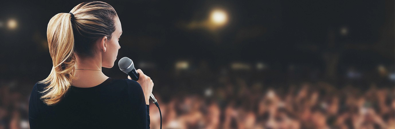 Woman on stage talking to audience
