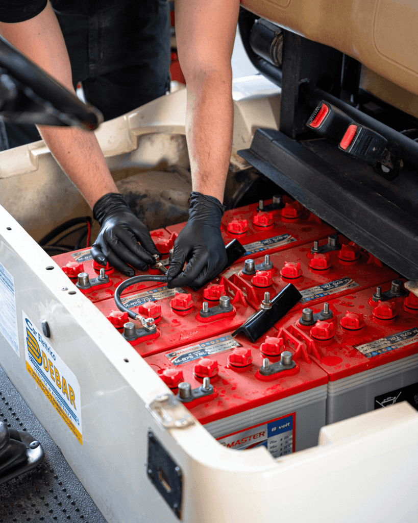 operazione di sostituzione batterie in una golf car