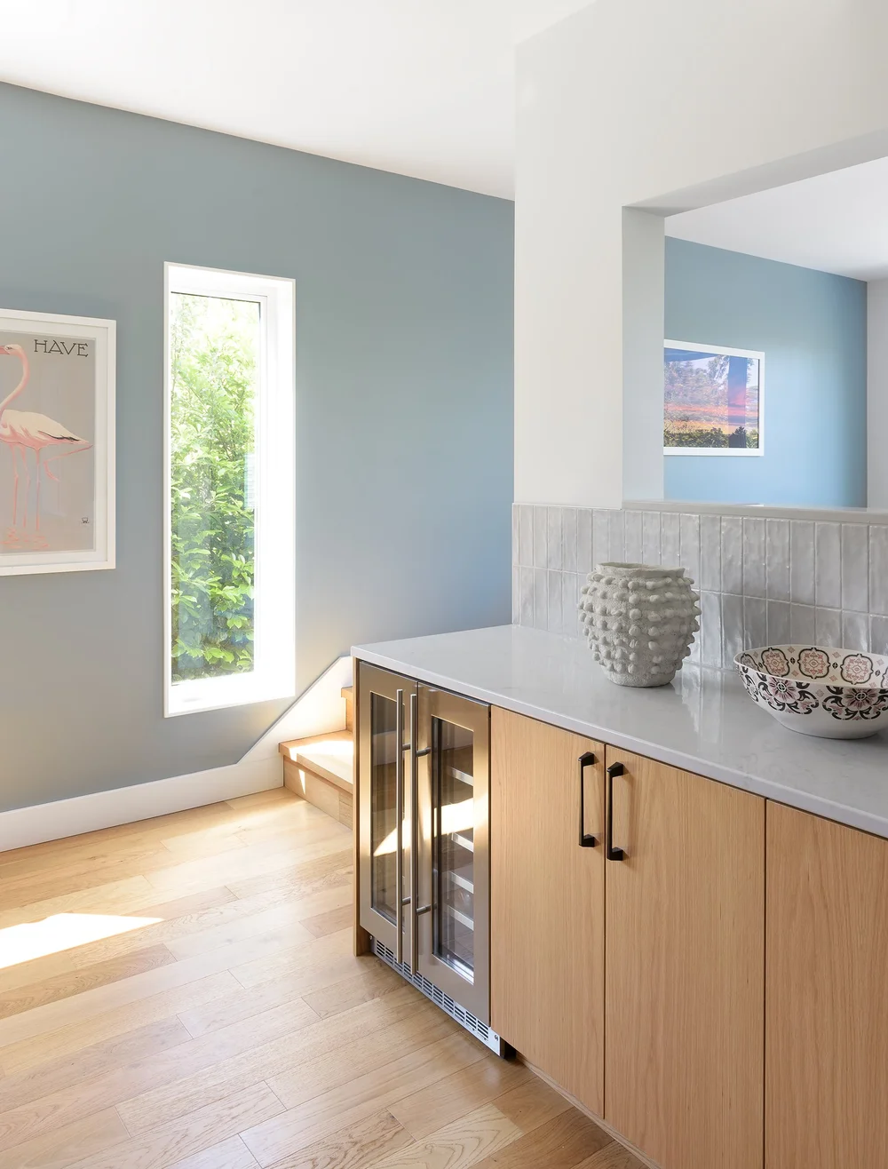 Modern two-story home with large glass windows, warmly lit interiors, and a balcony. Surrounded by trees and a manicured lawn at dusk. Cozy ambiance.