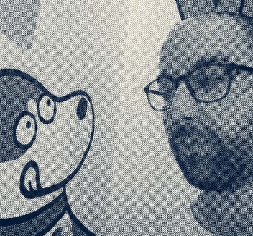 Haltone imaage of Fulcra Creative Founder Andy Strong looking whimsily at a cartoon dog on a wall. 