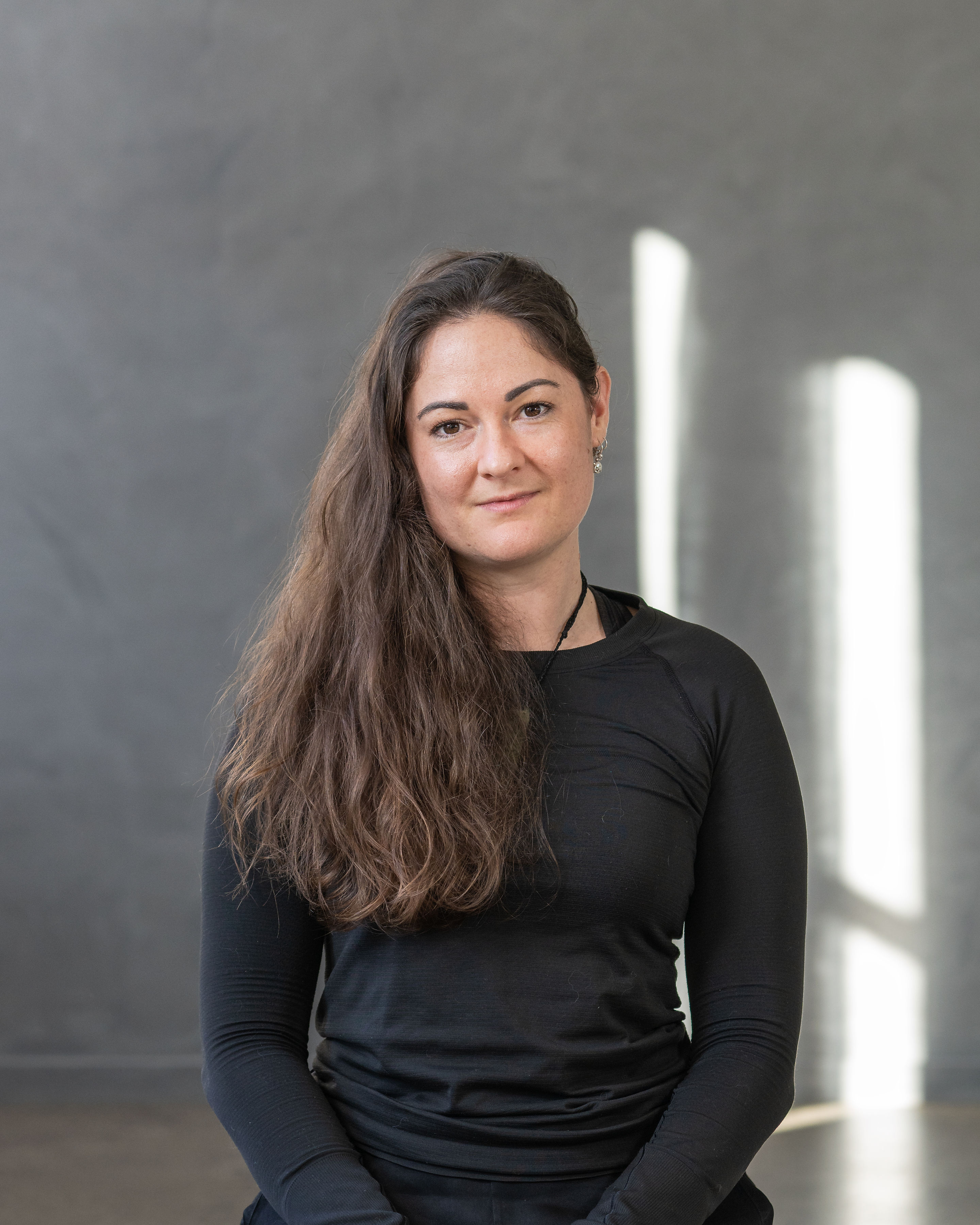Black cosmetic product bottle against a dark background