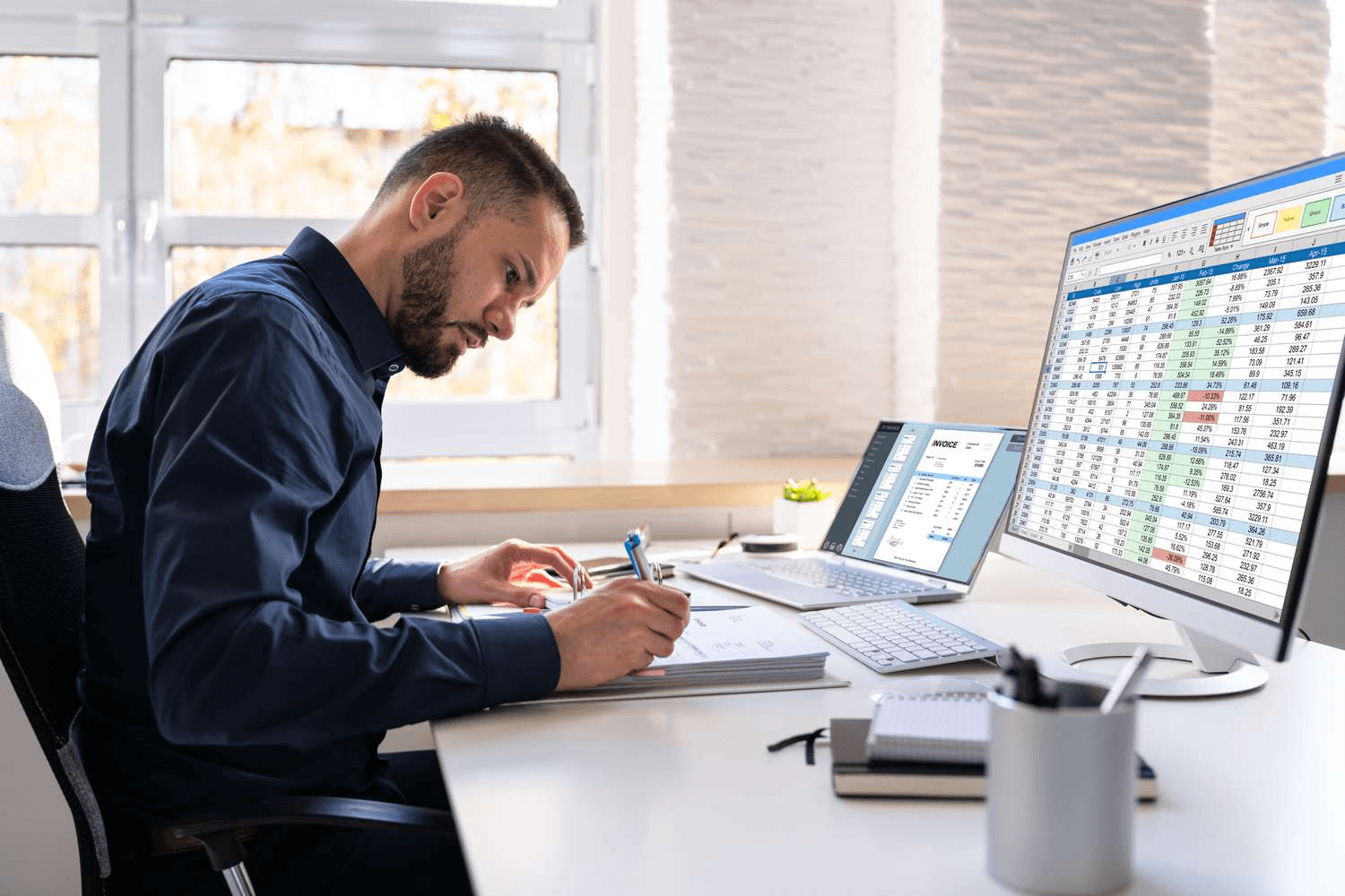 Man reviewing financial data and invoices - How to Track Business Expenses in Excel
