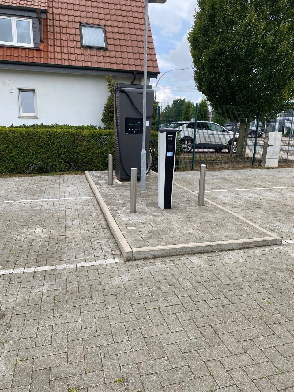 Elektroauto Ladestation auf Parkplatz. E-Ladesäule für nachhaltige Mobilität. Strom tanken.
