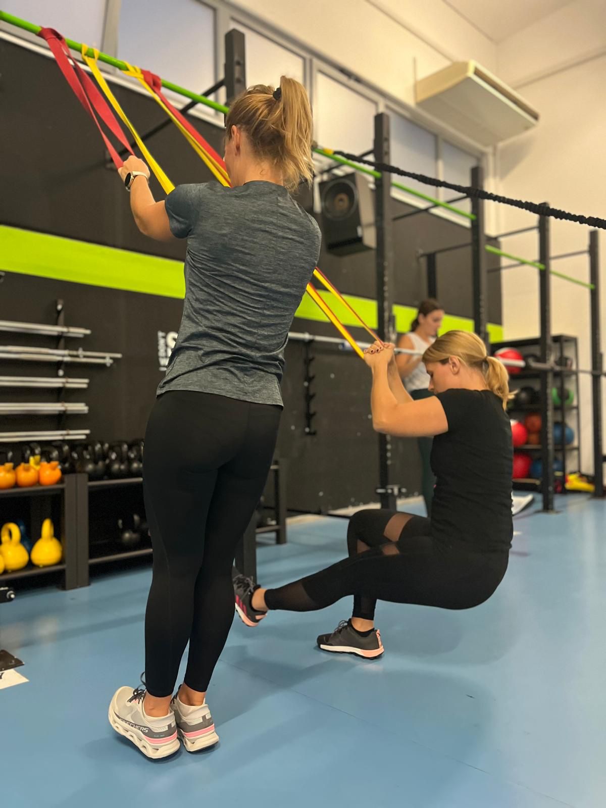 Žena se priprema za trening snage u fitness dvorani, fokusirana i motivirana za vježbanje.