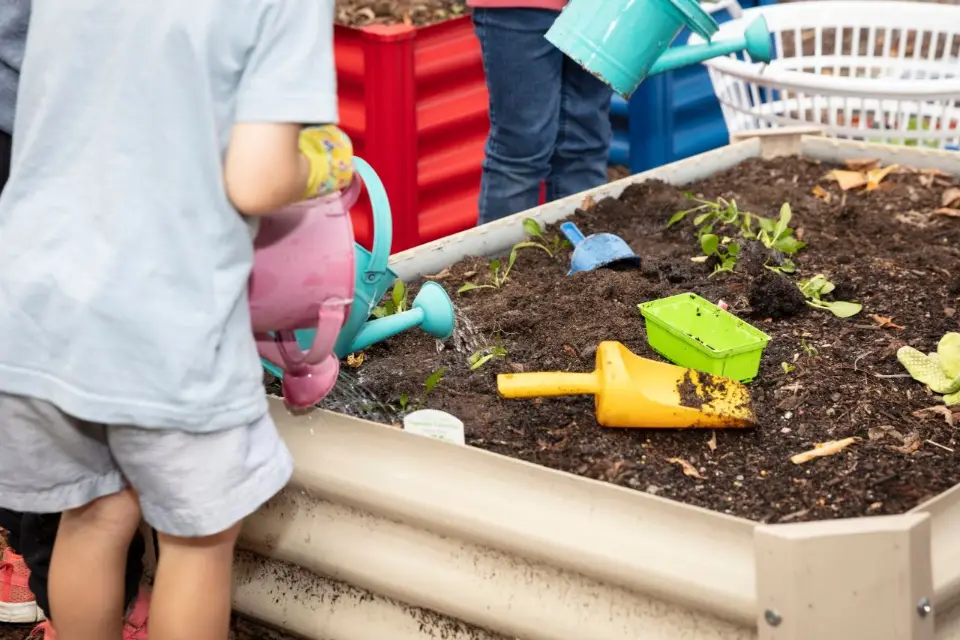 A sandpit with colorful toys and children playing
