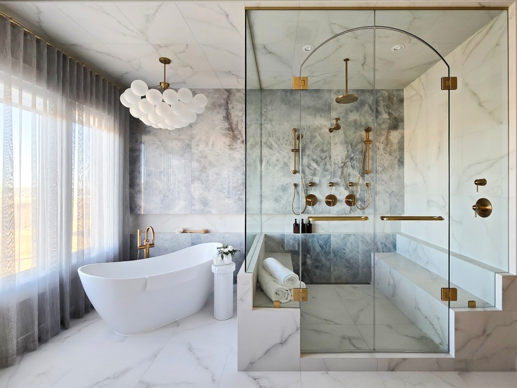 Image of Luxurious primary ensuite bathroom with marble design, gold fixtures, and KHD Homes design-build renovations expertise.