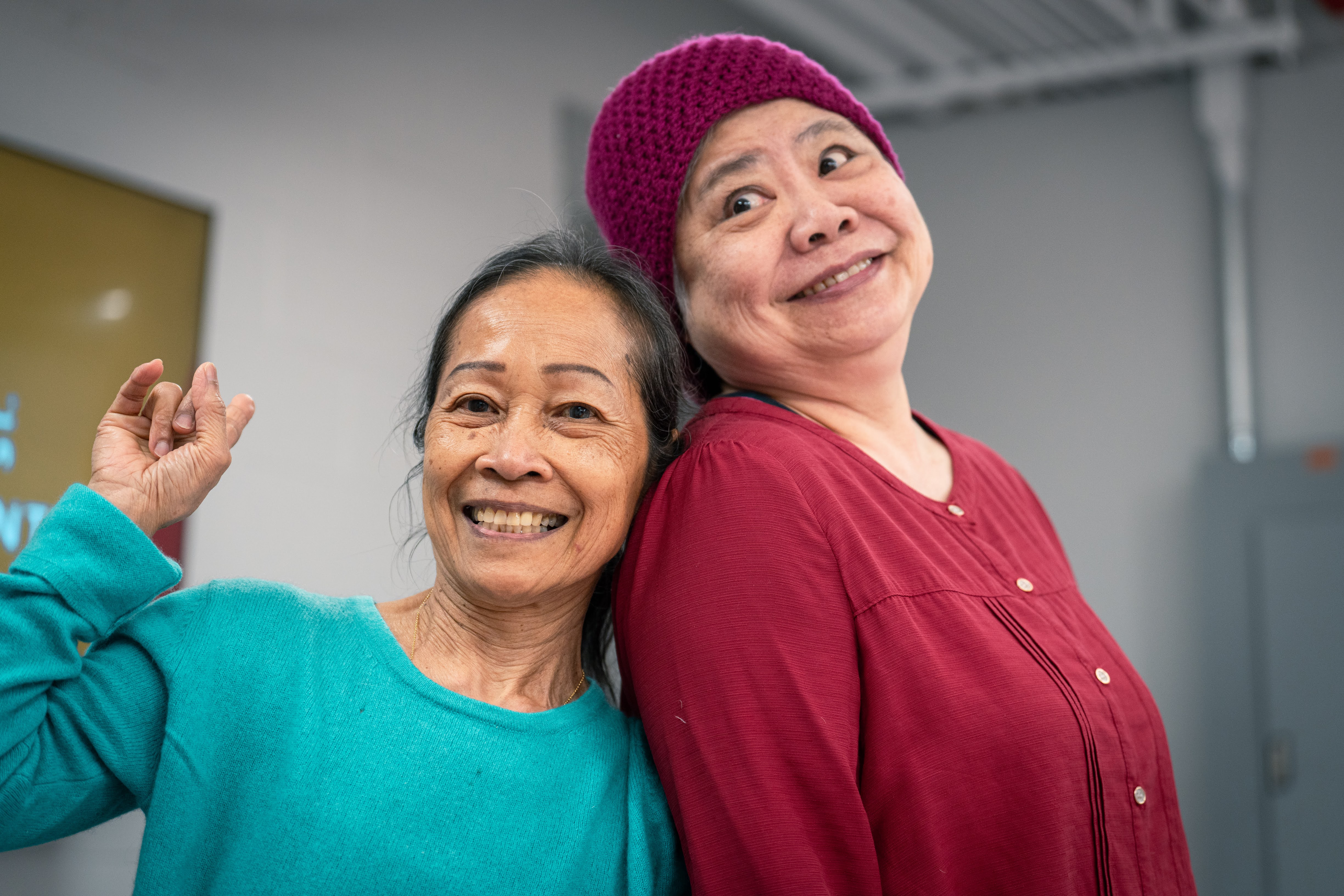 Two older adults pose for a photo with big smiles