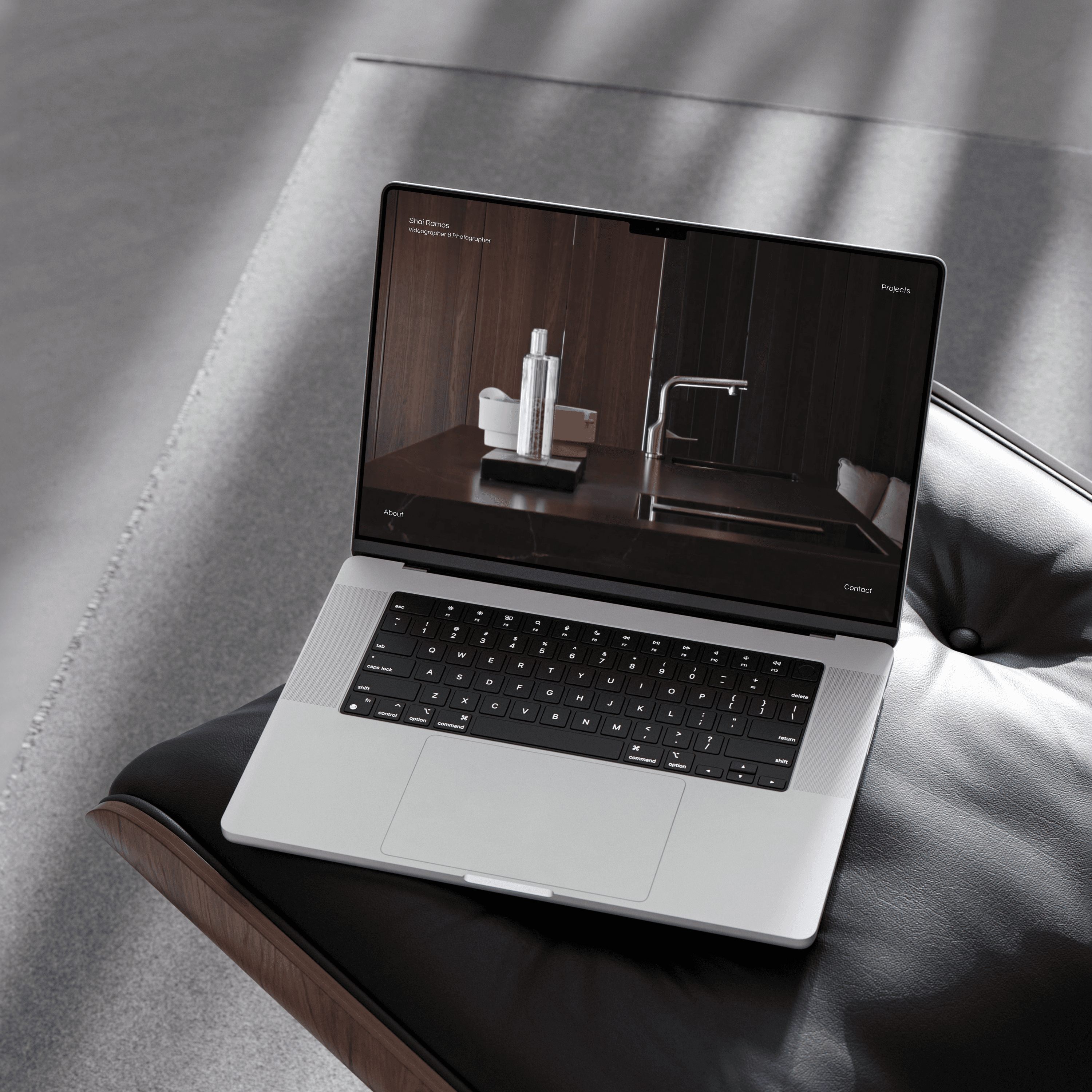 A lap top showing the website on top of a slick armchair