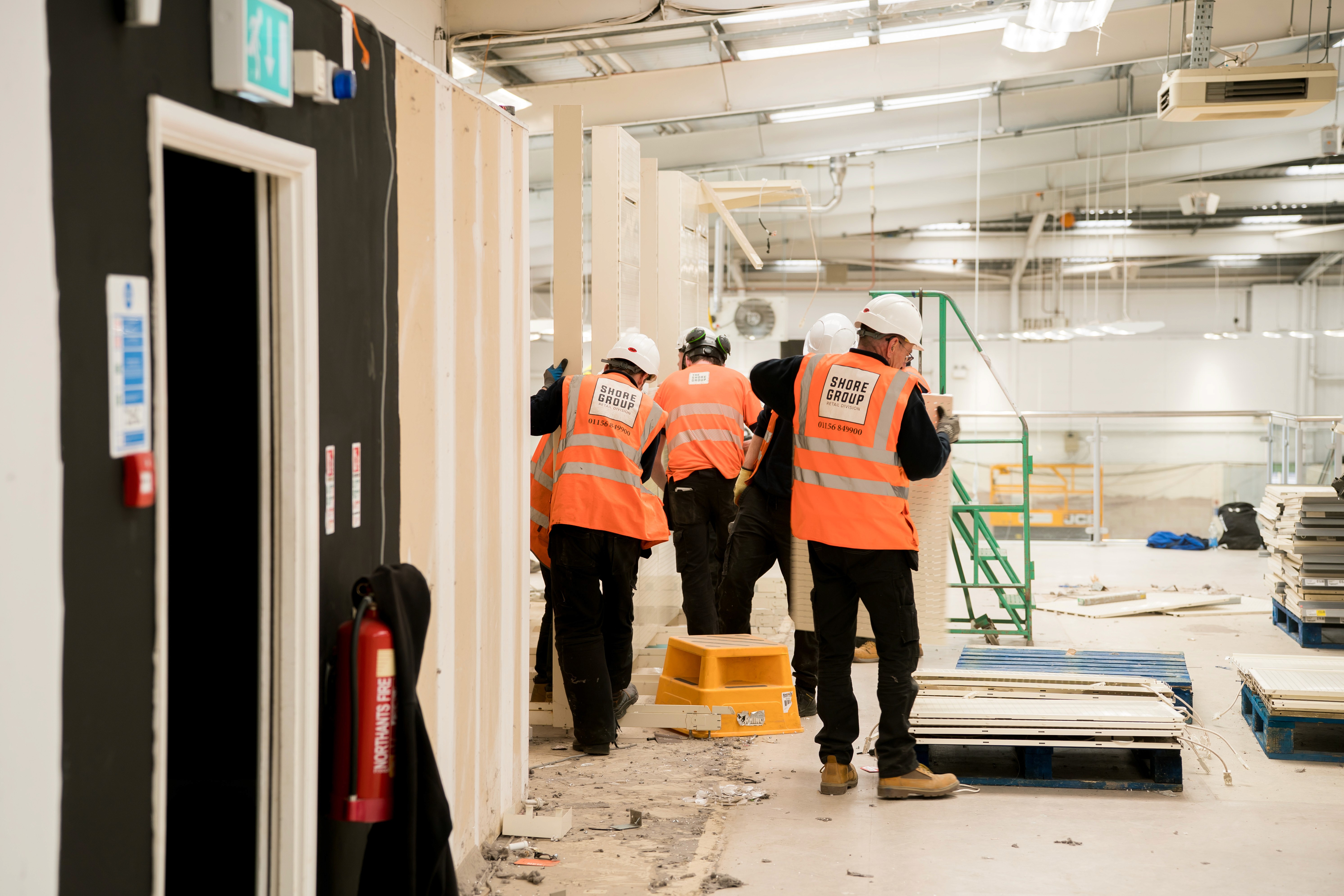 A digger inside a warehouse under construction
