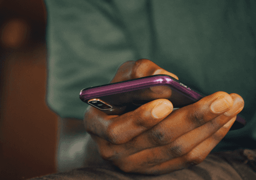 A close-up of a person's hand, holding a smartphone.