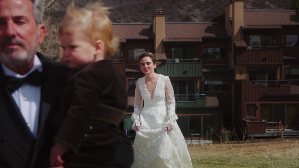 Bride in wedding gown outside the Snowmass family home before Catholic ceremony in Aspen