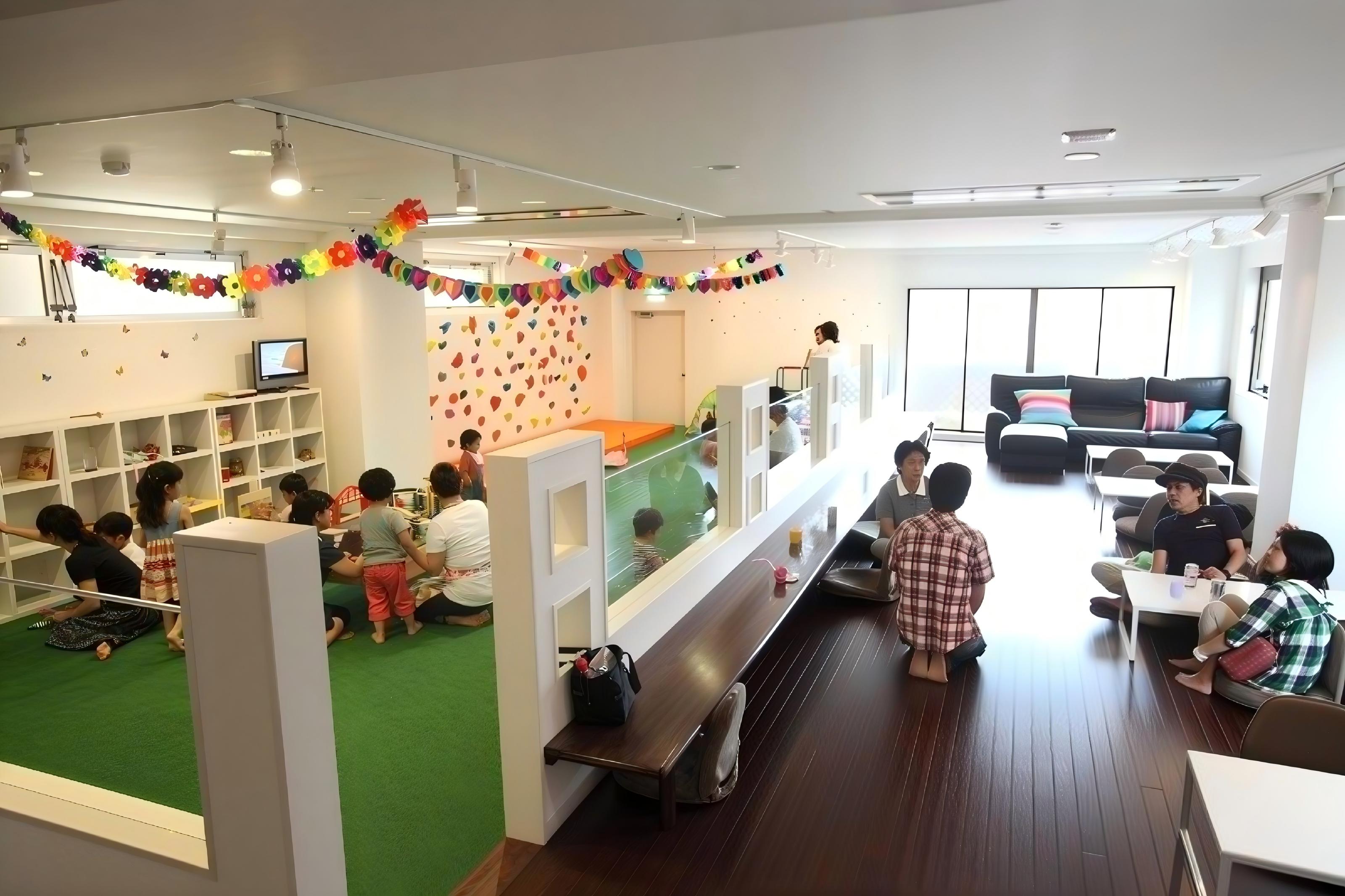 面向機場兒童遊樂區的落地玻璃餐廳設計，家長可一邊用餐一邊觀看遊樂設施內的小朋友 (Glass-front restaurant next to airport kids playground allowing parents to dine while watching children play)