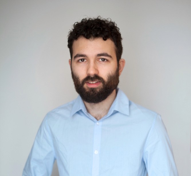 Portrait of a laughing person with curly hair wearing a white shirt