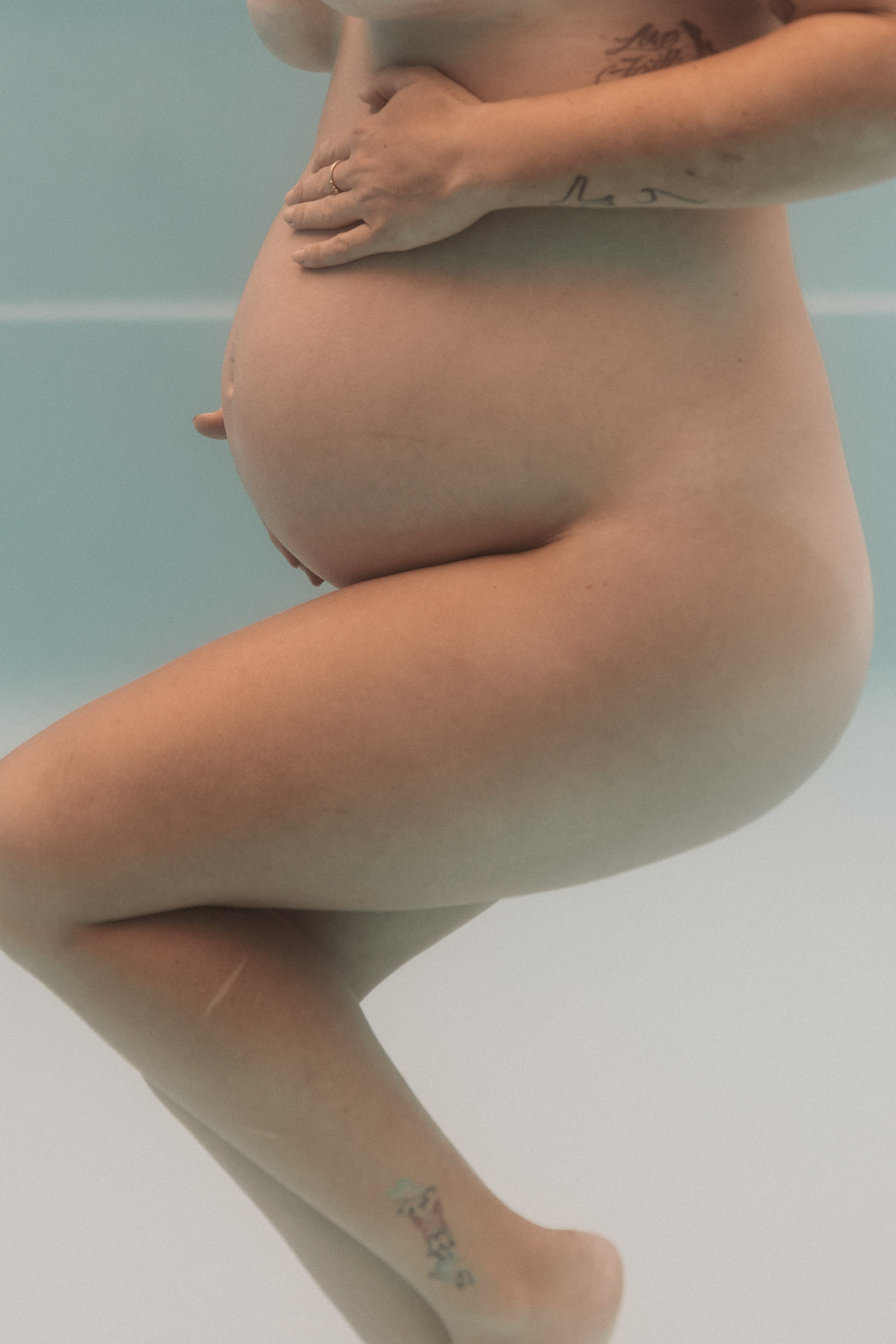 Editorial underwater maternity portrait with sunlight reflections in Queensland pool