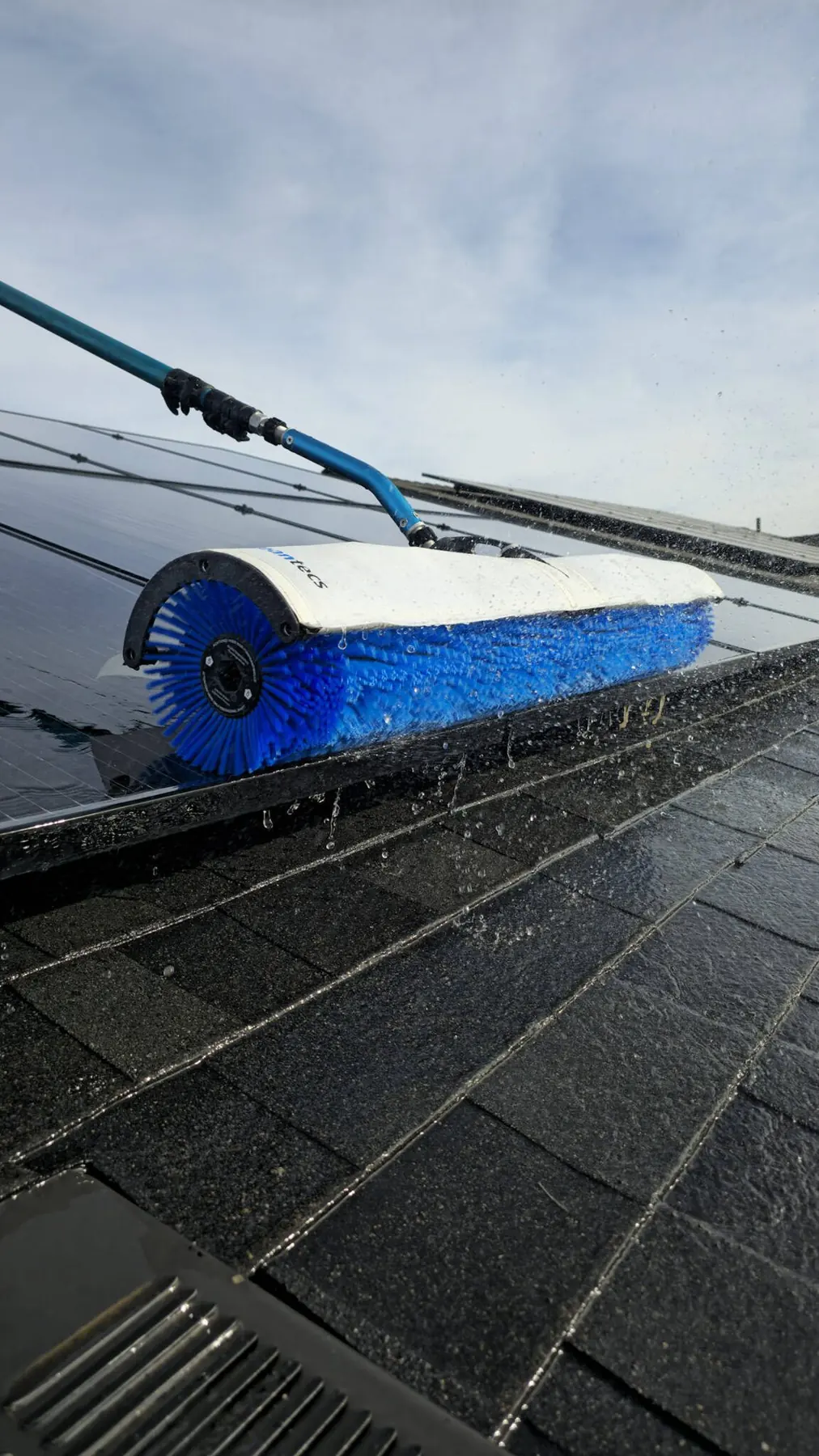 Blue rotary brush cleaning solar panels, close-up | Premier Solar Service, serving Fresno, CA
