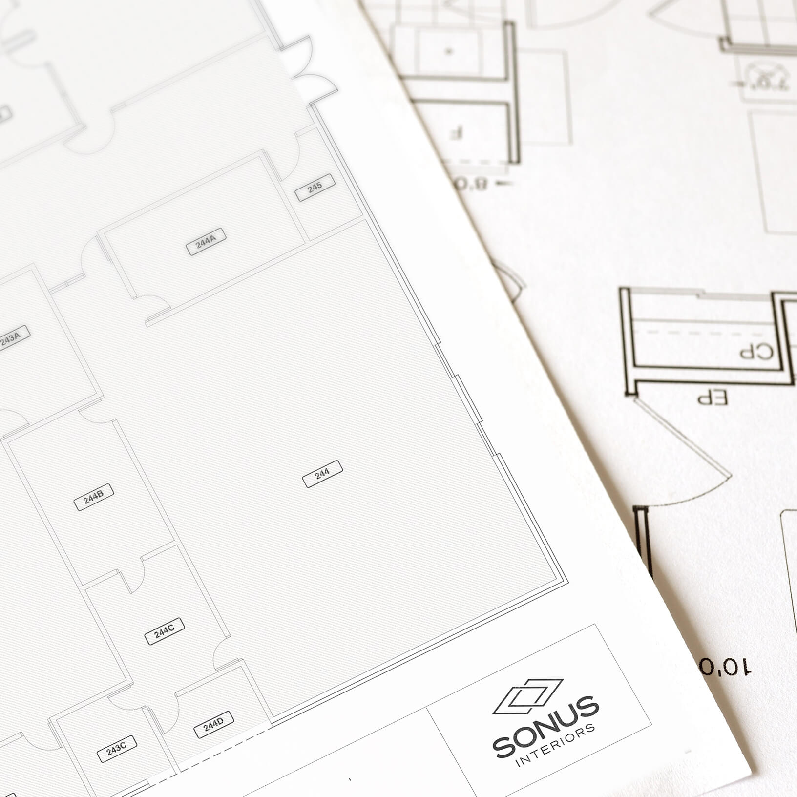 Stack of blueprint pages with the Sonus Interiors logo.