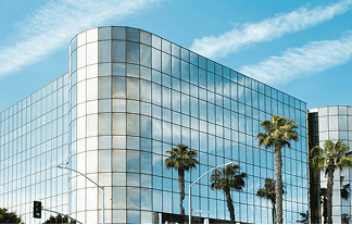 Two colleagues collaborating over paperwork at an office desk, with plants in the background.