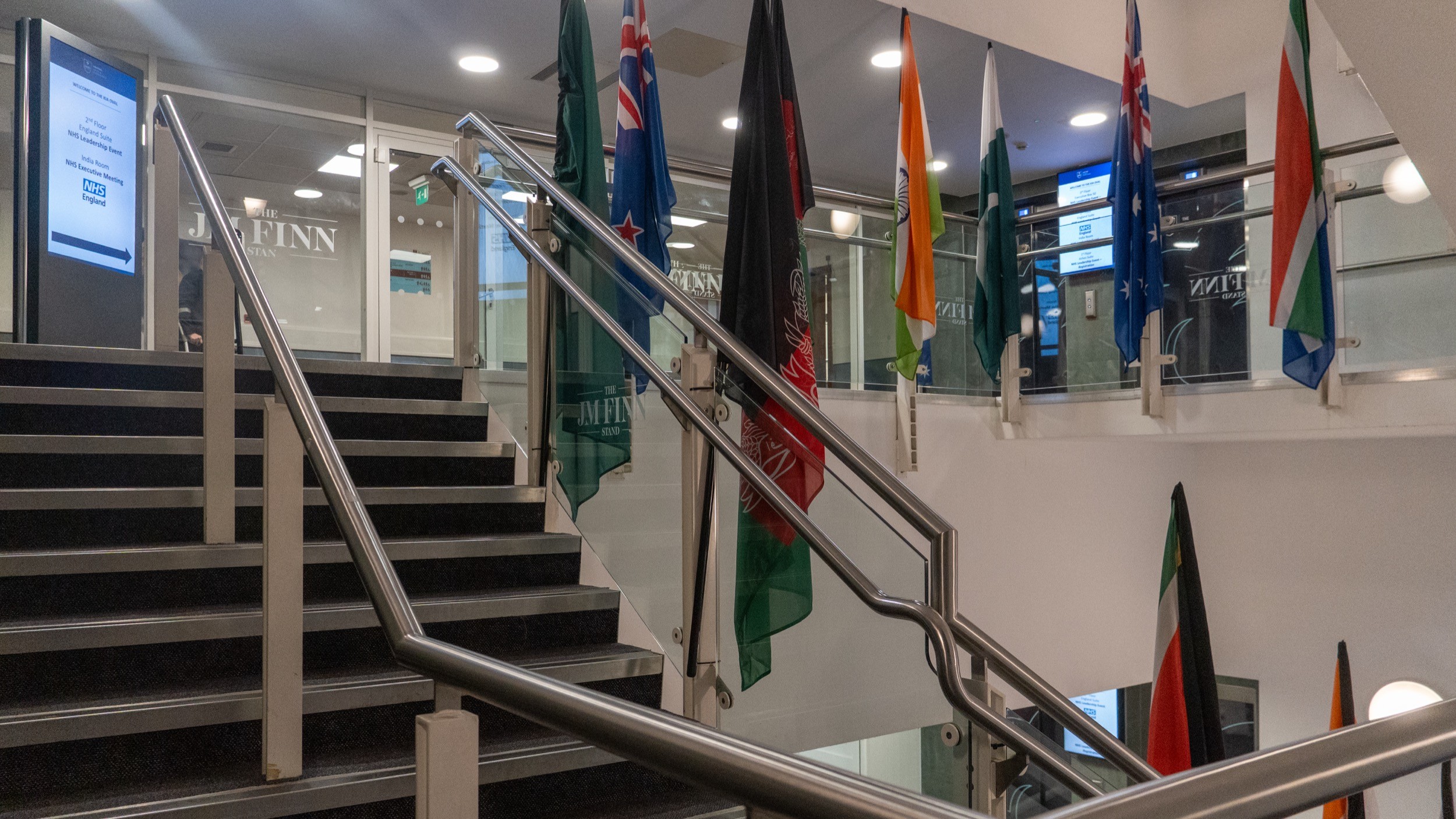 Two classic volkswagen beetles, one green, one cream.