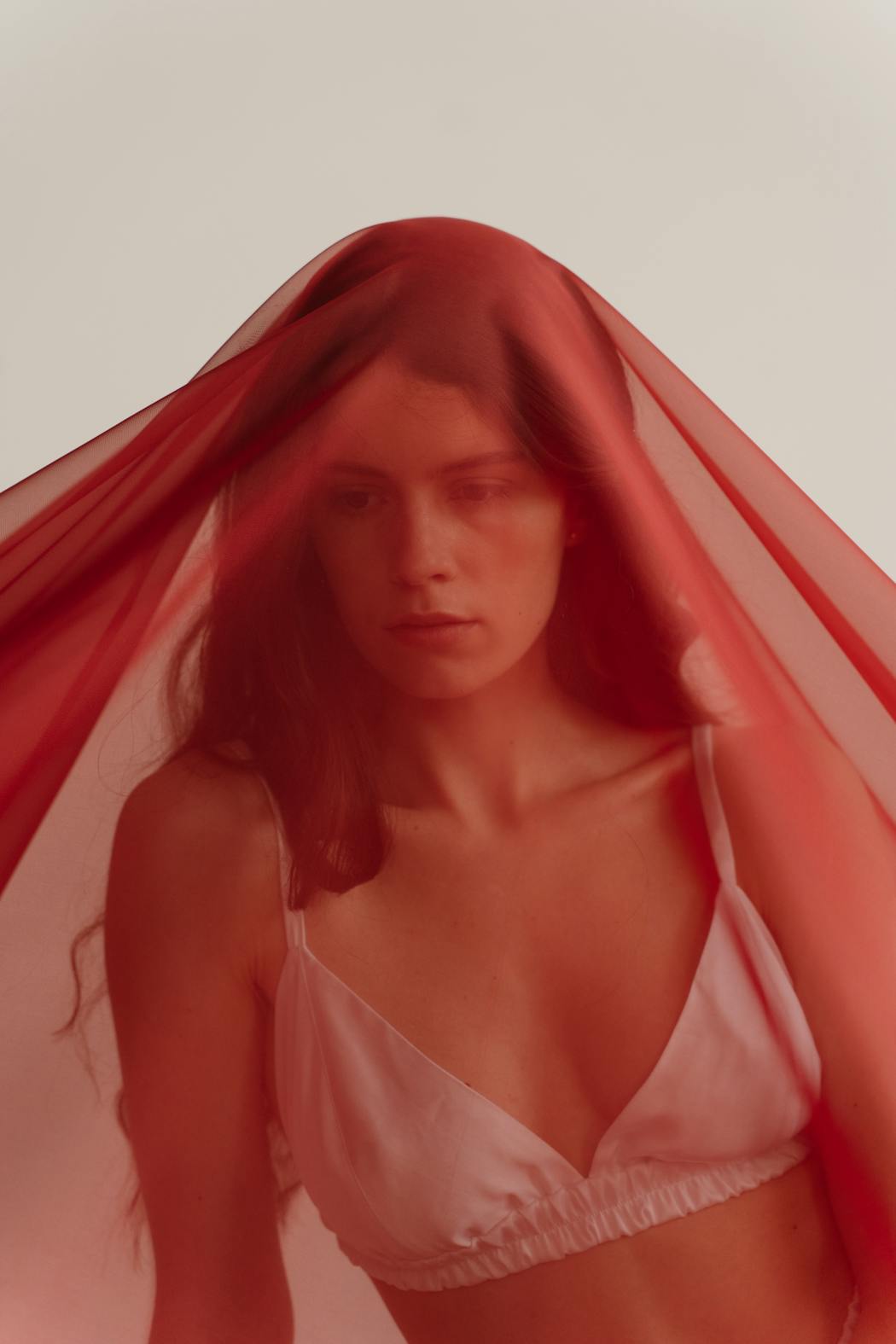Woman in white brassiere covered with red textile