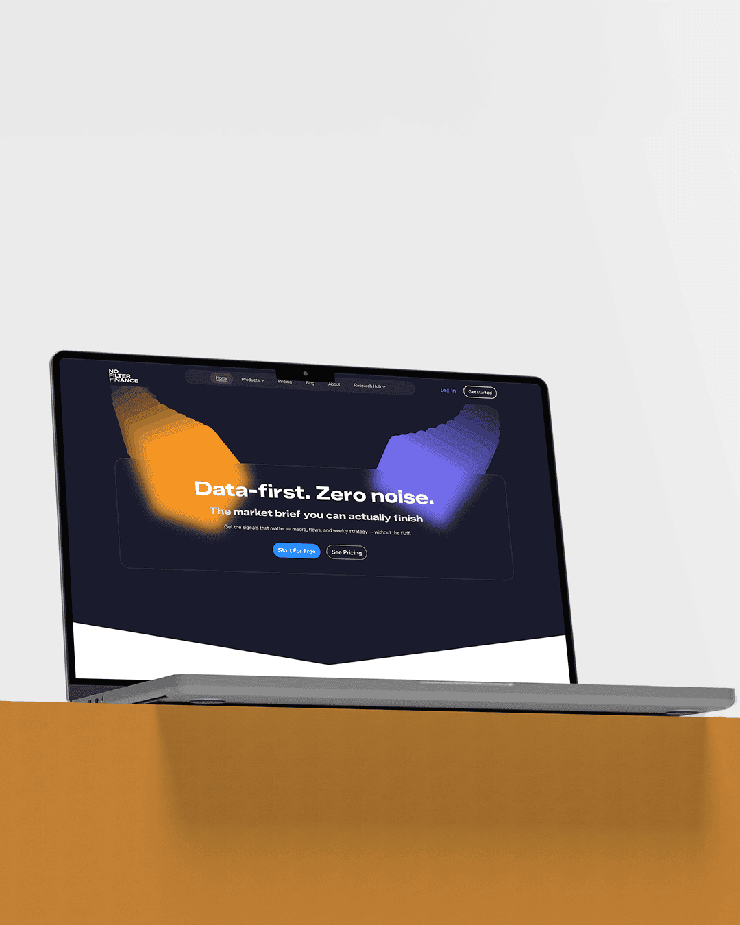 A laptop on a wooden desk displaying a website with an orange and blue abstract design on a dark background.