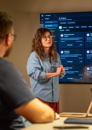 Man and woman working side by side at a desk, both focused on their laptops.