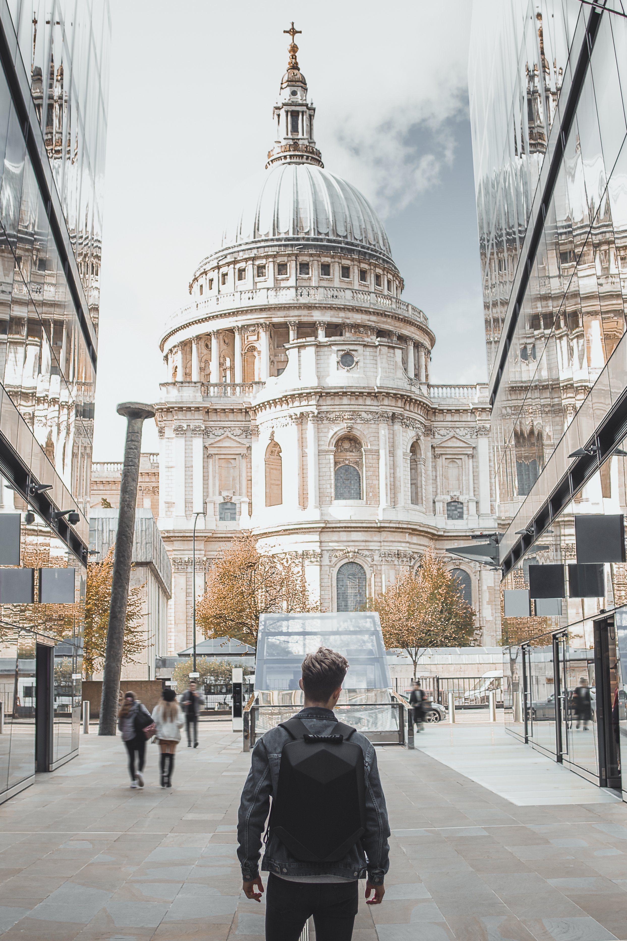 A person walking towards St Paul’s Cathedral between buildings in London.