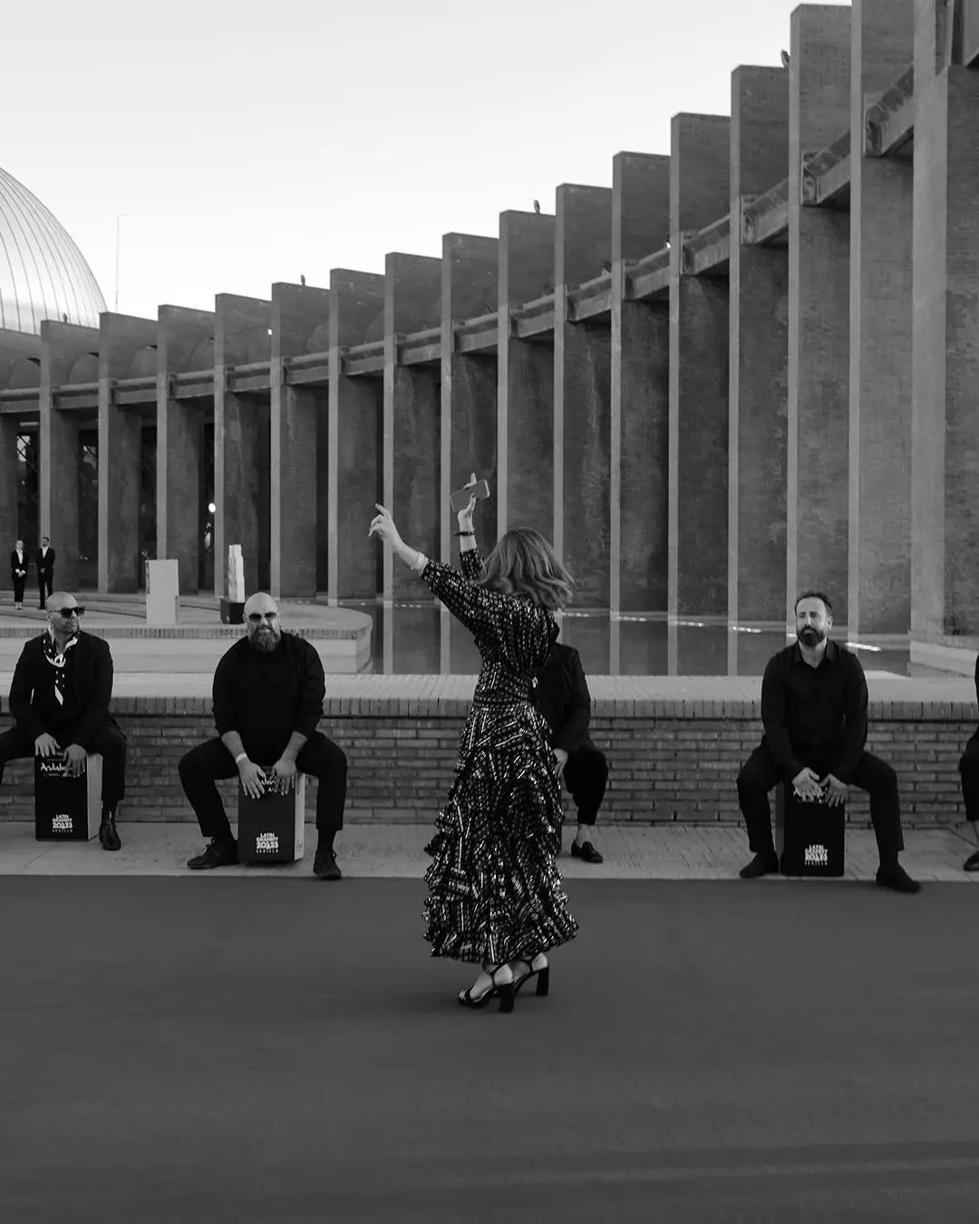 Flamenca bailando acompañada de cajones tocando detrás