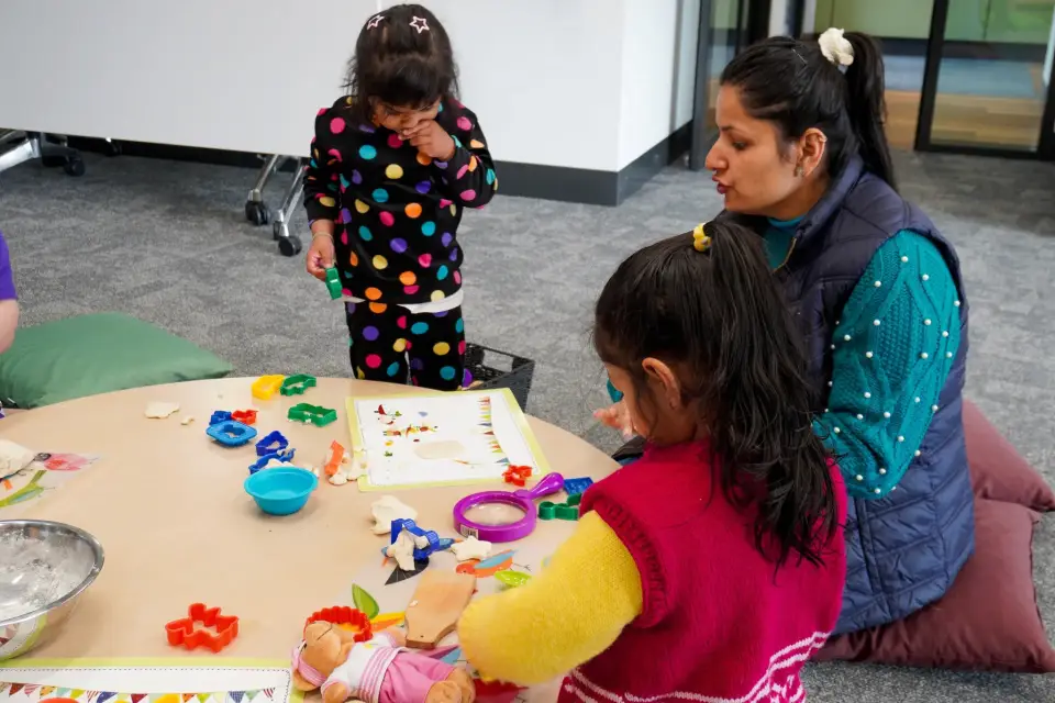 Children around a table build blocks and solve puzzles