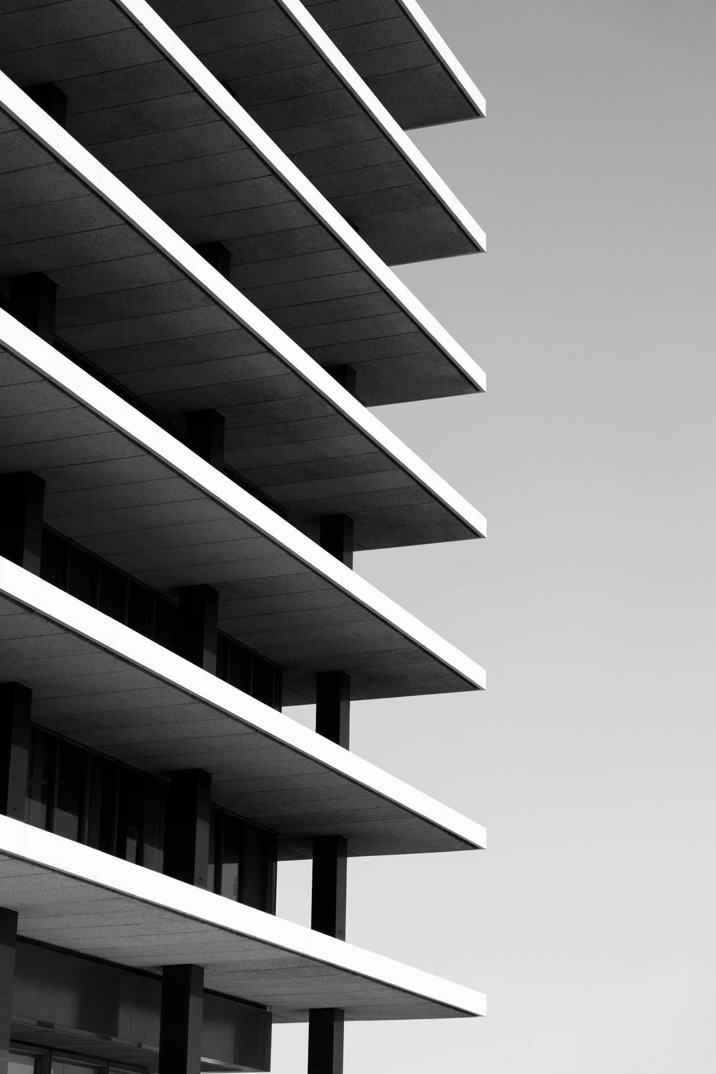 Thin cantilevered balcony slabs on a white apartment building