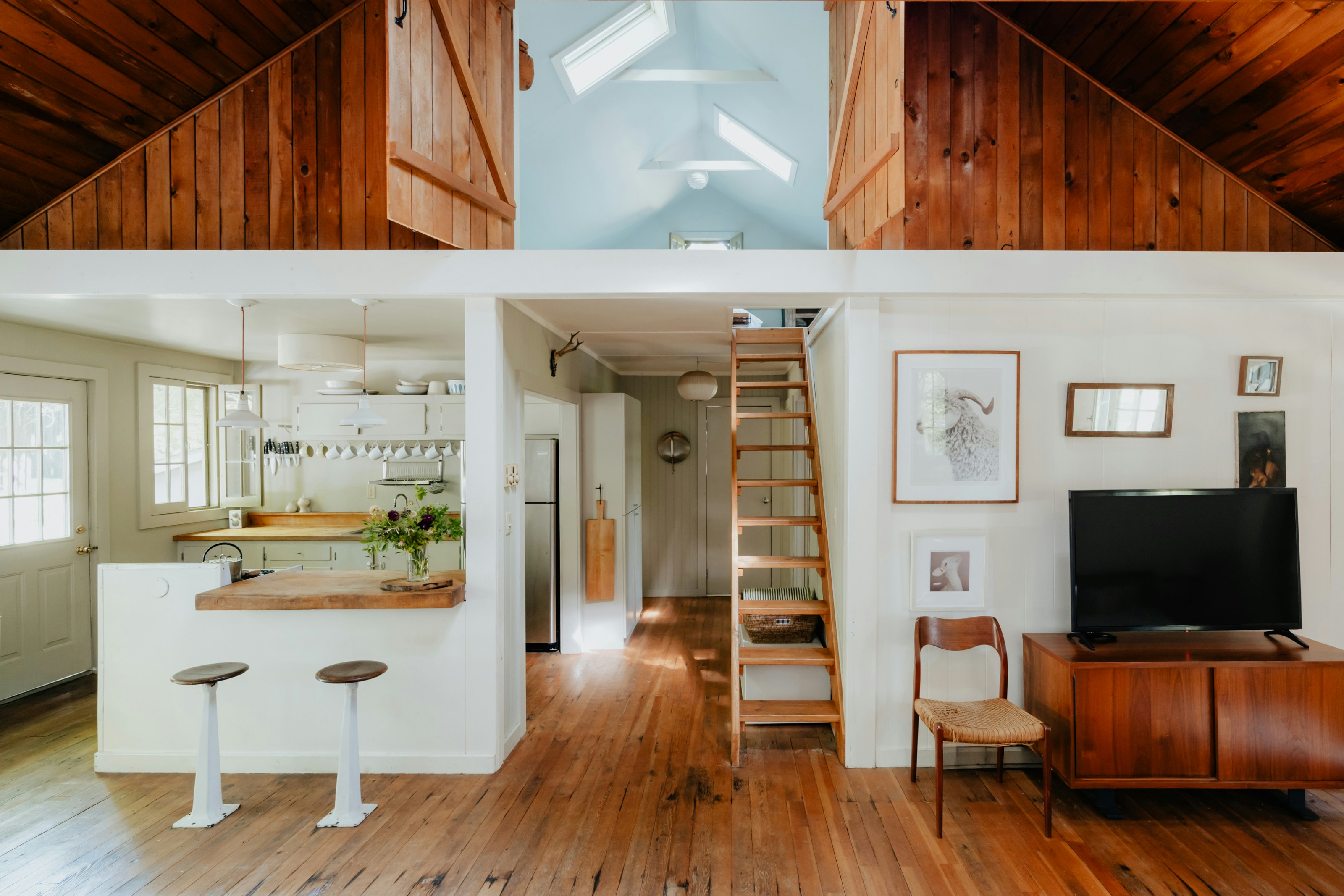 Open-plan living area with a kitchen island and exposed brick walls.