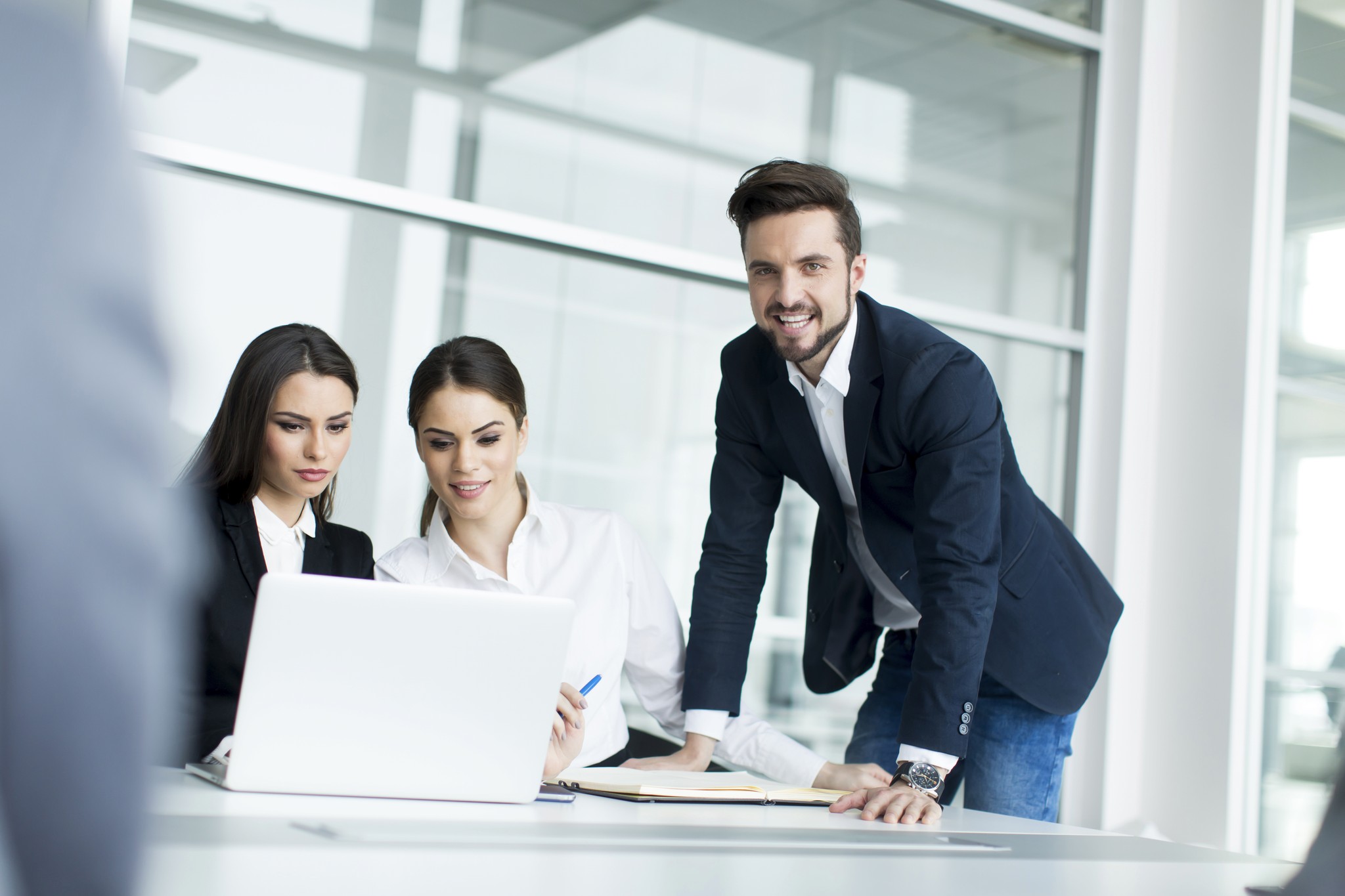 Office workers collaborating on a laptop computer