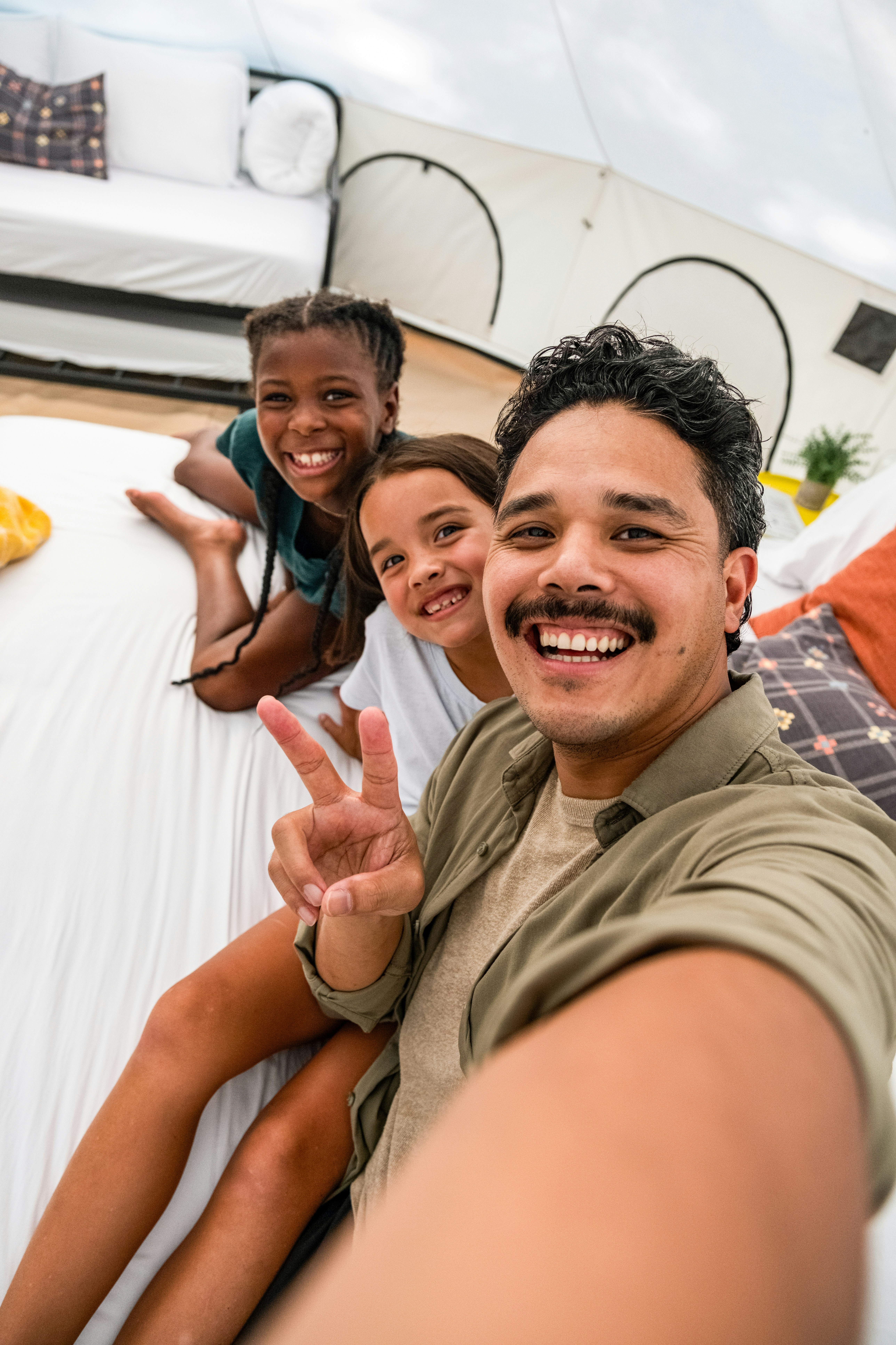 Man and two girls taking a selfie in a tent