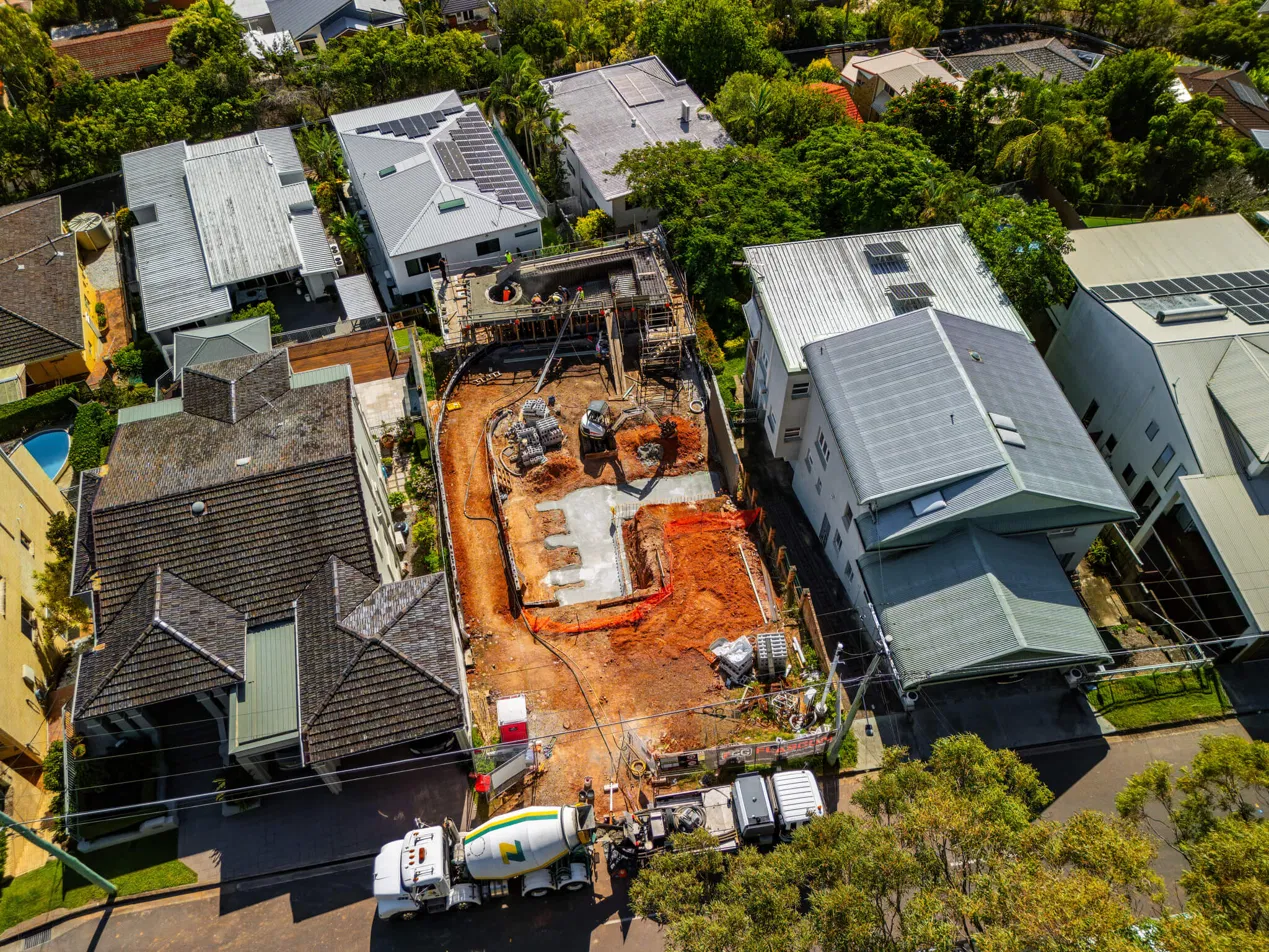 Aerial view of a Flascon construction site mid-build, showing staged concrete works on a tight Brisbane block