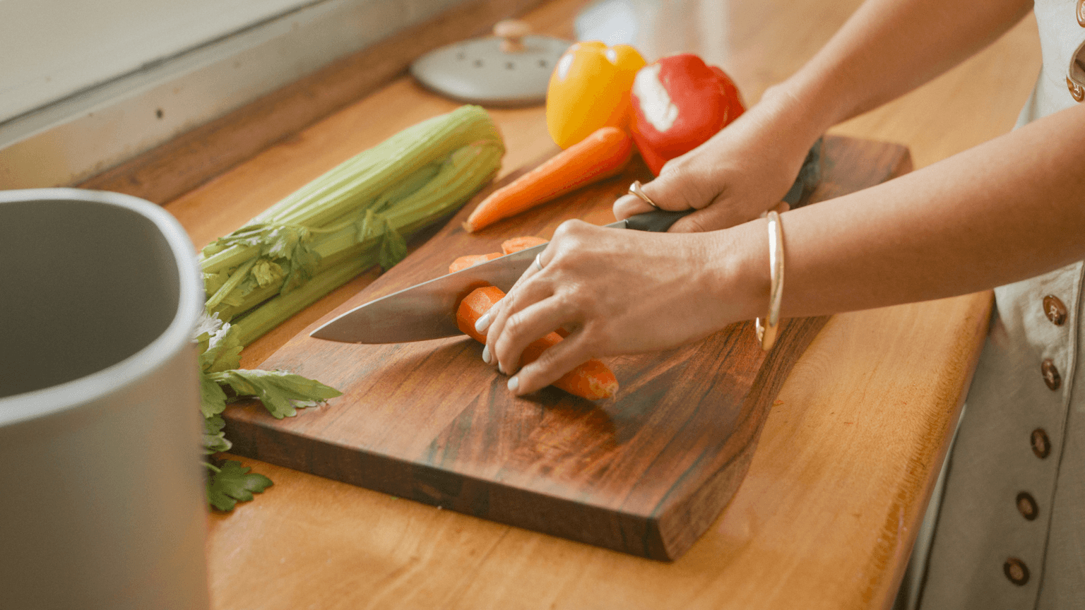 Person cutting up carrots on a chopping board