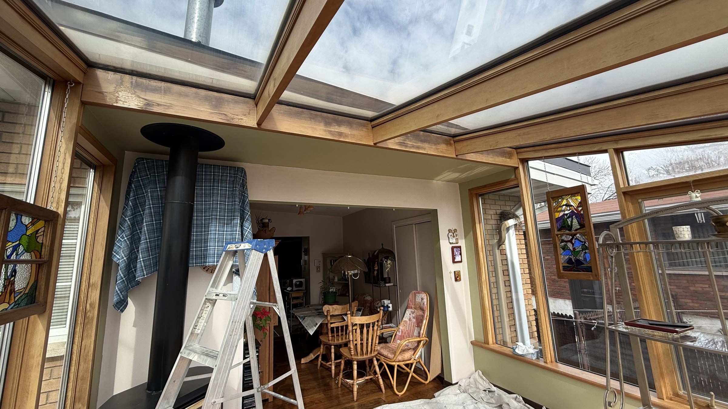Laval sunroom with wood-framed windows during restoration