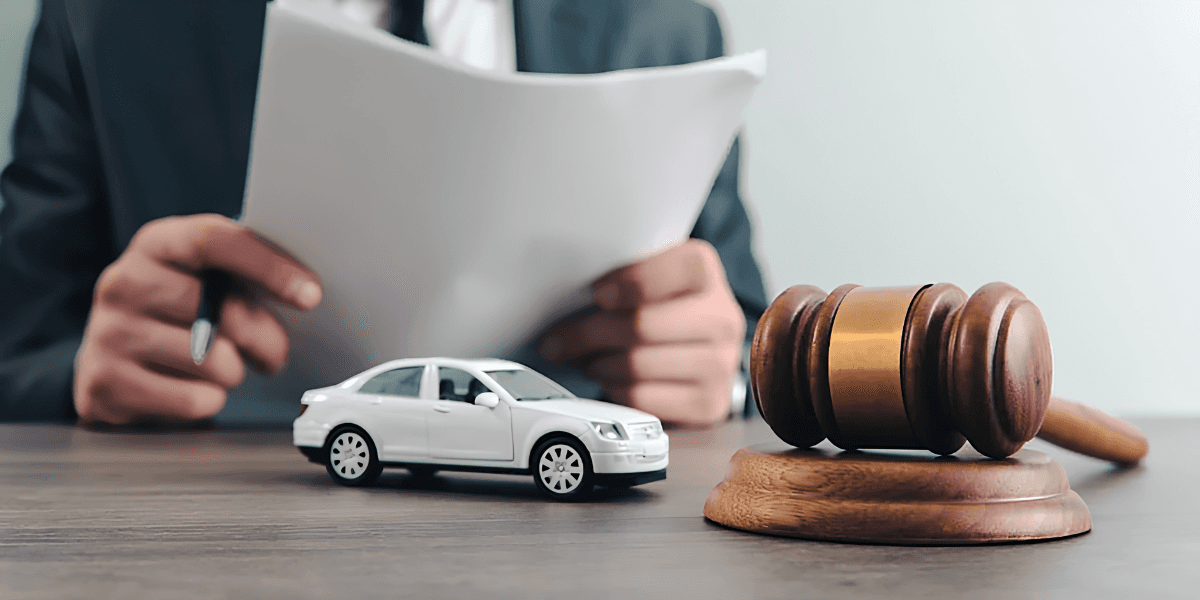 Judge’s gavel and toy car beside legal documents representing financial and legal recovery after a car accident.