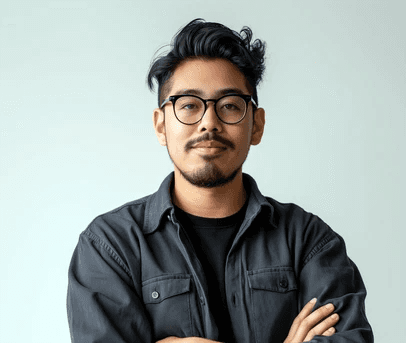 A man with glasses standing in front of a building