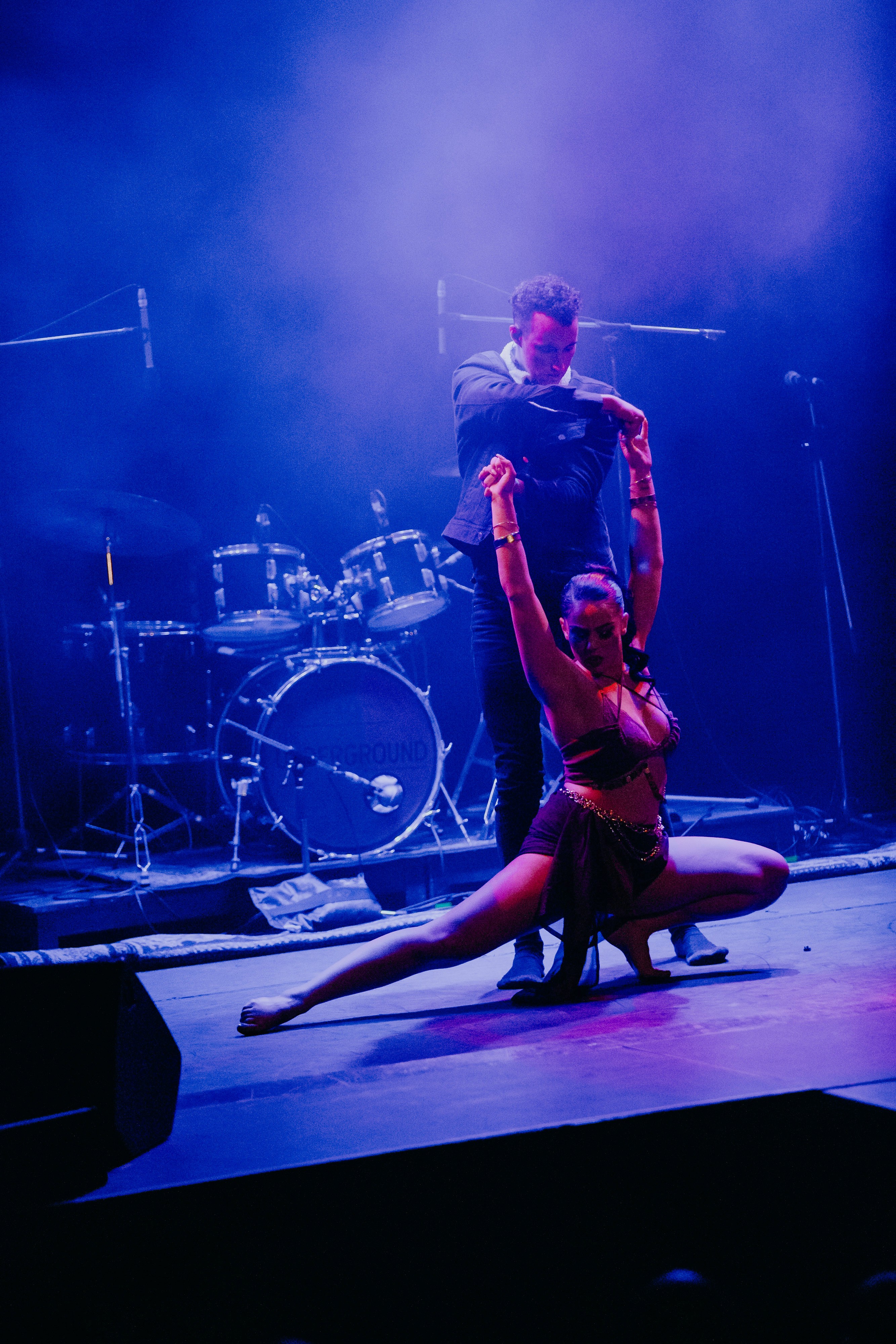 Person, holding a white rose behind his back with one arm on a light blue background