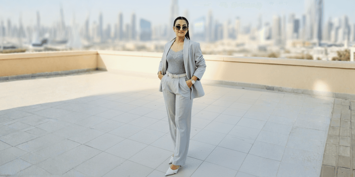 Prachi Dalal standing confidently in Dubai, wearing a stylish gray suit, offering expert guidance on off-plan real estate investments.