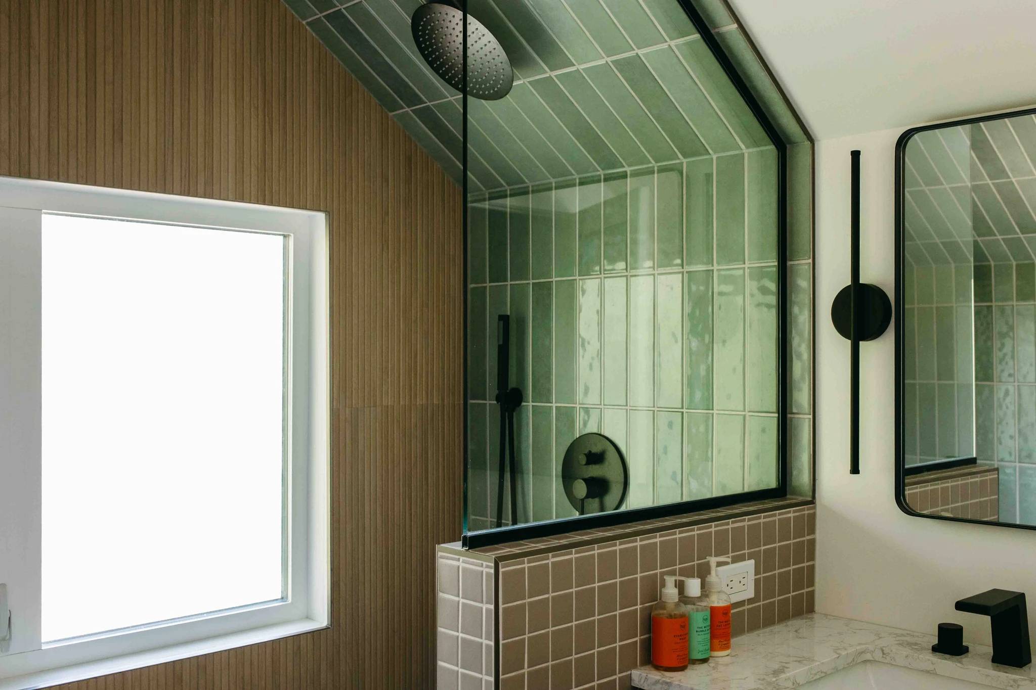 Details of a renovated Saskatoon washroom including custom tile in the shower and around the window