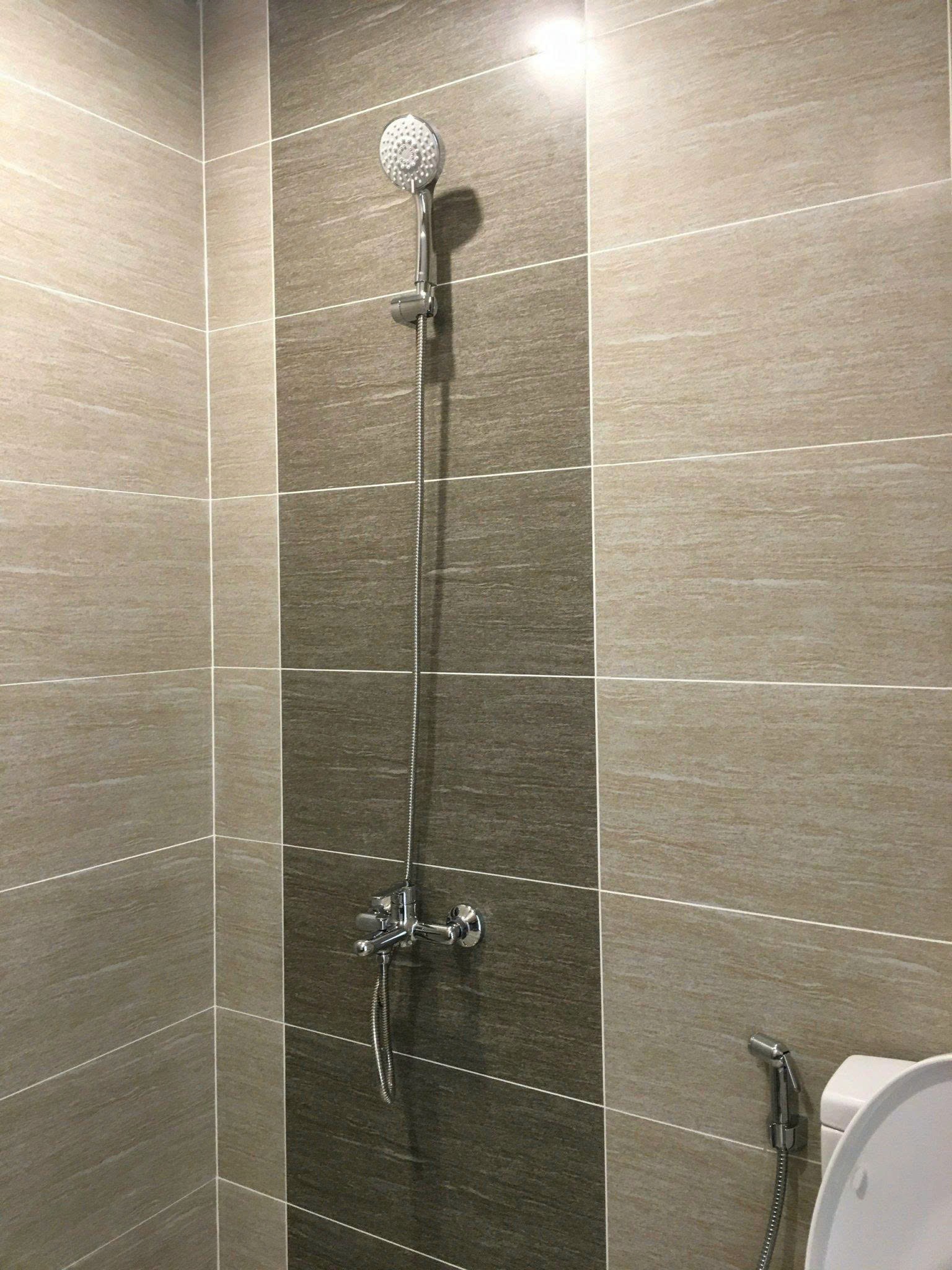 Phòng tắm theo phong cách tối giản với bàn lavabo treo tường, gương lớn và các chi tiết trang trí bằng gỗ.