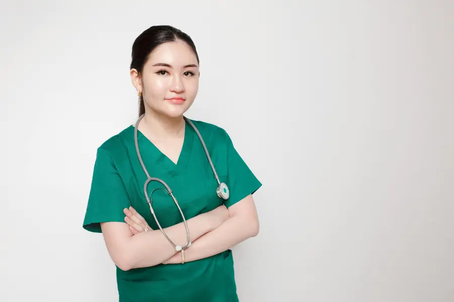 Confident nurse in green scrubs with stethoscope standing arms crossed representing AI nurse triage software support.