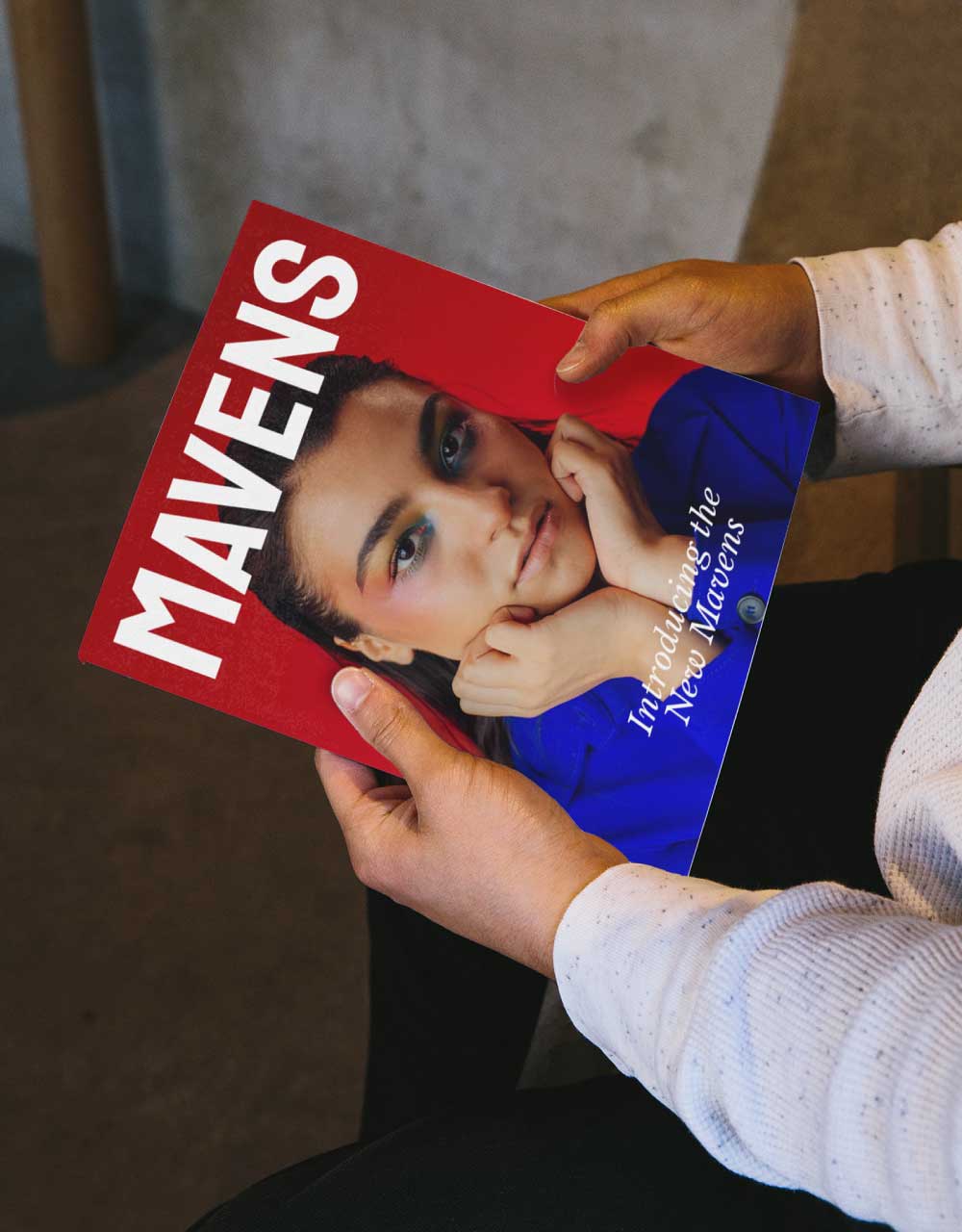 Hands holding a red and blue MAVENS magazine cover reading "Introducing the New Mavens".