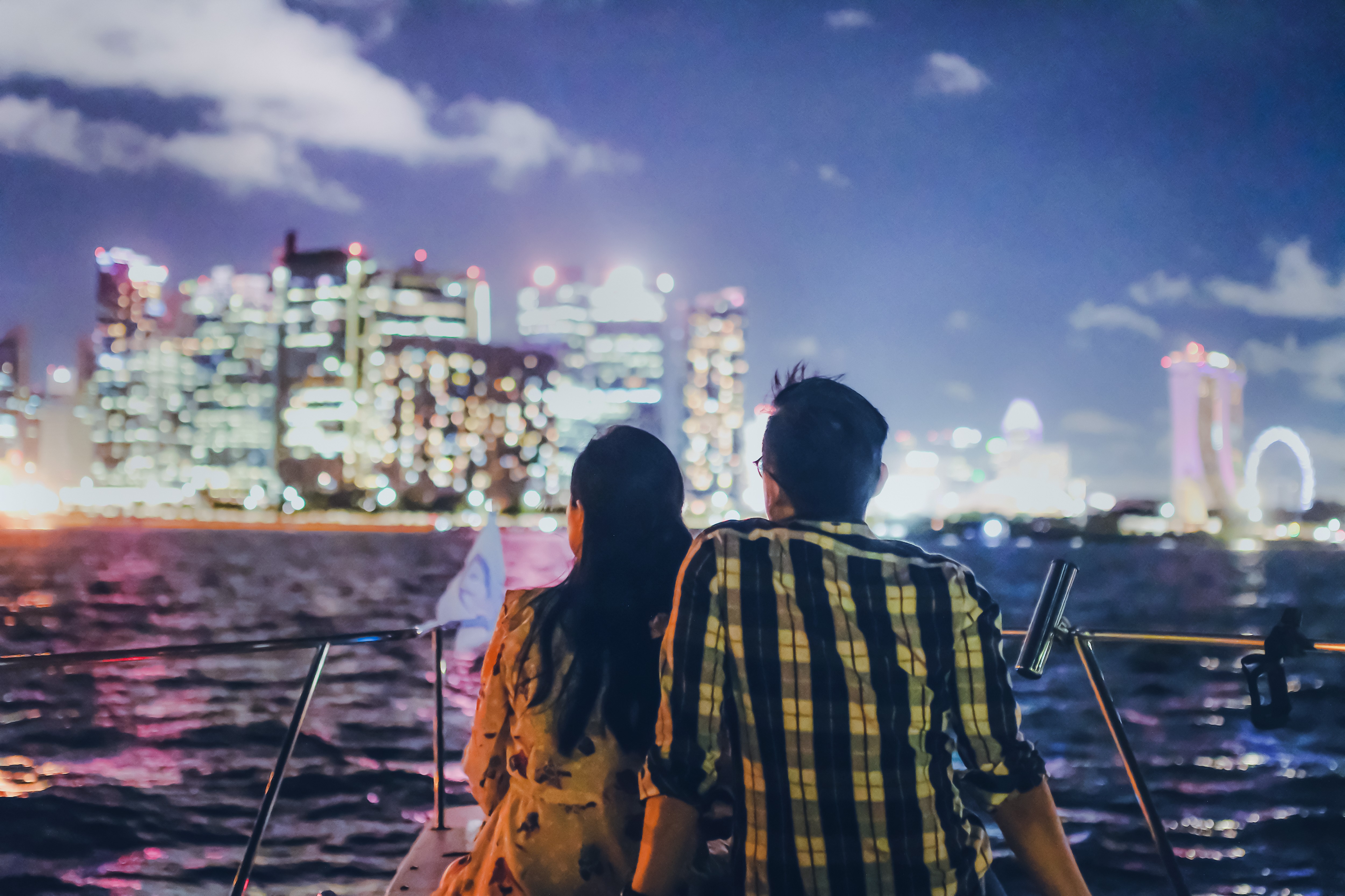 Marina Bay Sands yacht cruise with illuminated Singapore skyline at night.