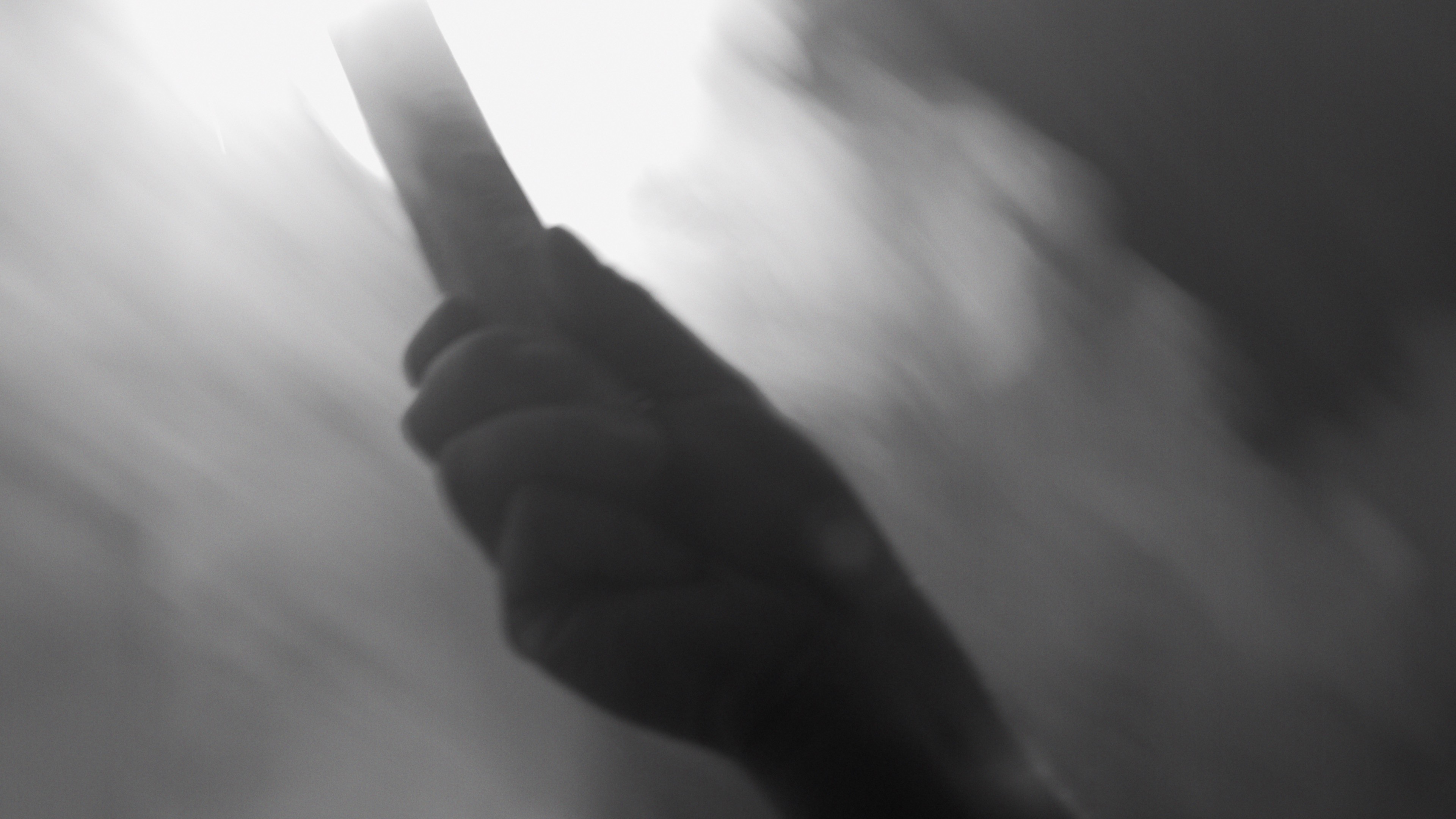 Close-up of a hand gripping a weapon, dynamic motion blur cinematography.