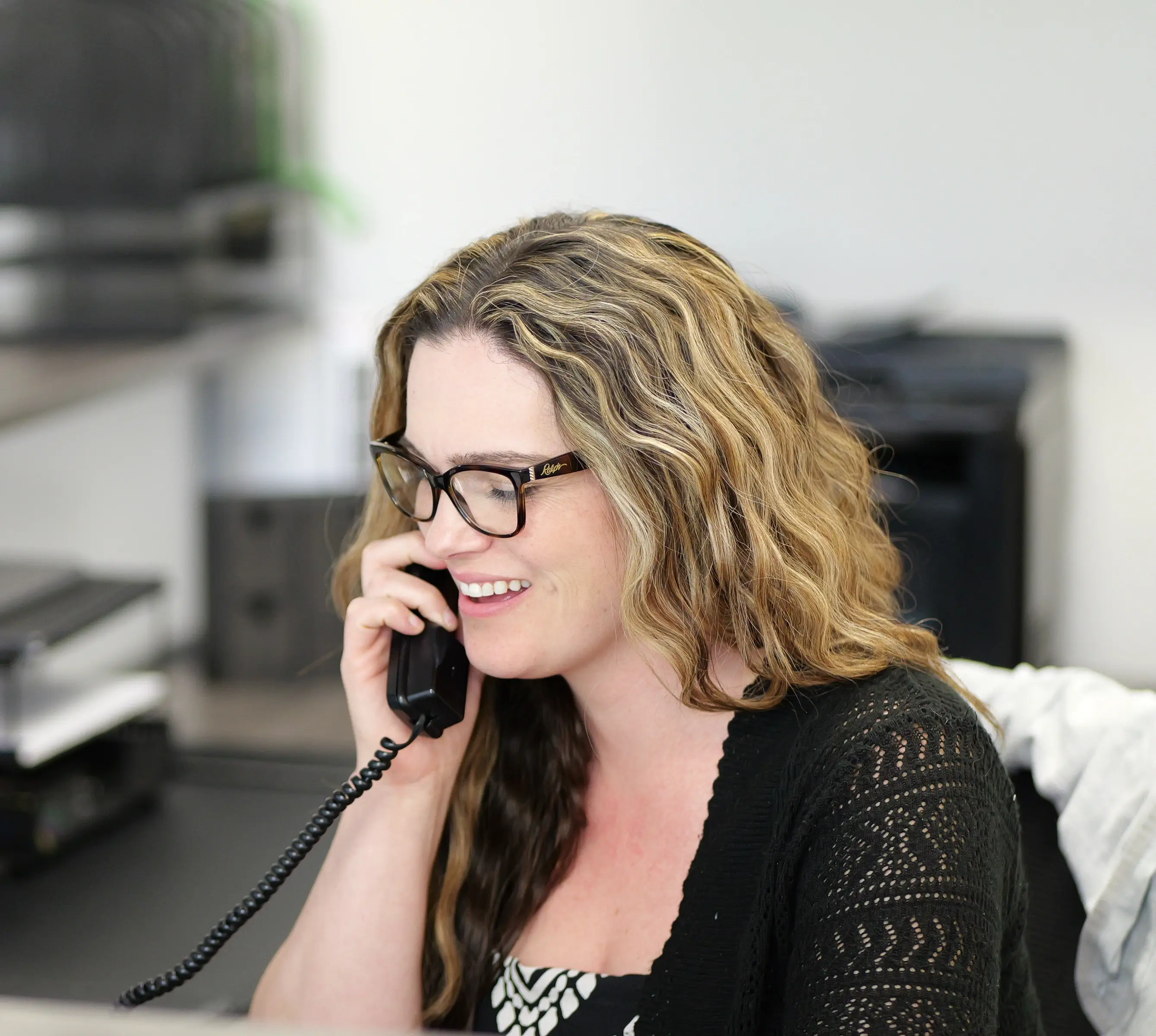 Woman at desk on phone with client