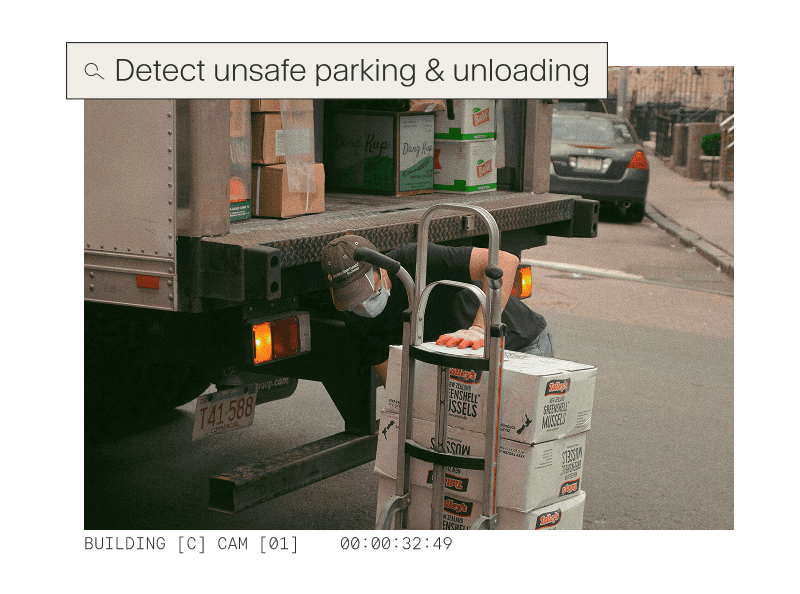 High-angle view of a delivery truck parked on a street with a pink "Detected" box identifying a safety violation during unloading.