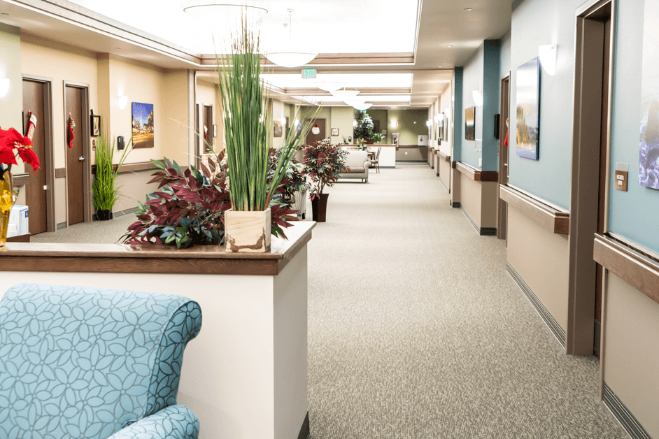 Central common area in a memory care community with resident rooms on both sides and open space for daily activities.