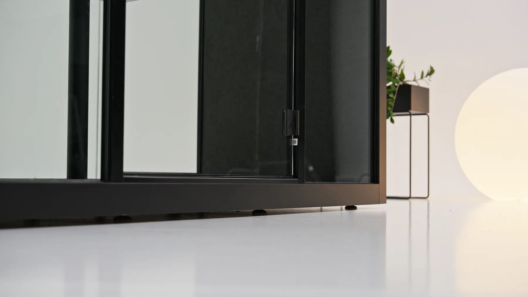 Close-up of a pod's door hinge and floor track meeting a light-colored floor