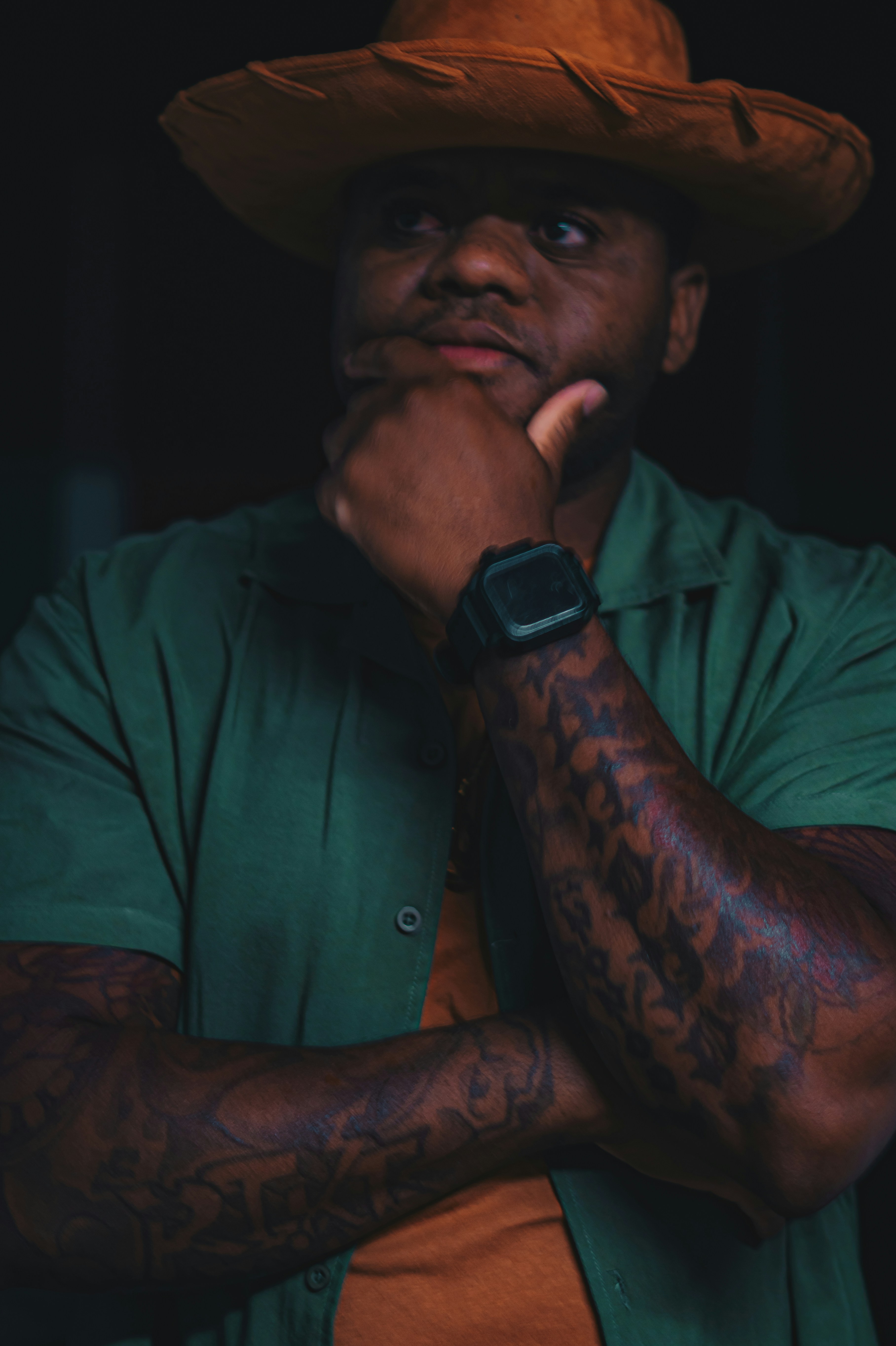 a man wearing a green shirt and a brown hat